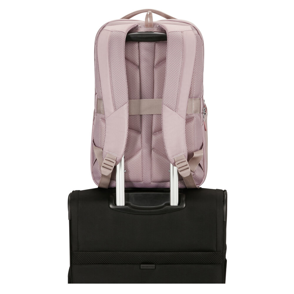 Ein mauvefarbener Rucksack steht auf einem schwarzen Koffer. Die Träger und der Rücken des Rucksacks sind sichtbar, ebenso wie der Griff und der Korpus des Koffers.