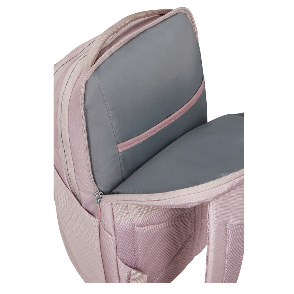 Nahaufnahme eines rosa Rucksacks mit offenem Fach, das einen grauen Innenraum zeigt. Der Reißverschluss ist sichtbar, mit einem Griff oben.