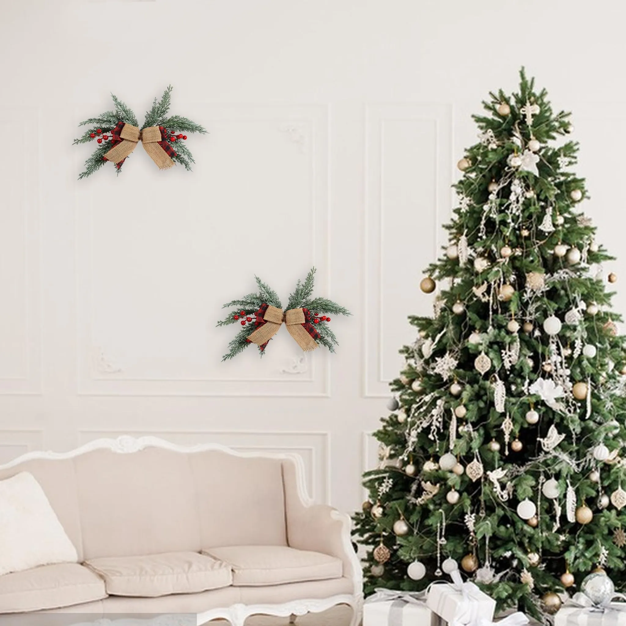 Ein geschmückter Weihnachtsbaum steht neben einer Wand mit zwei dekorativen Schleifen und einem beigen Sofa.