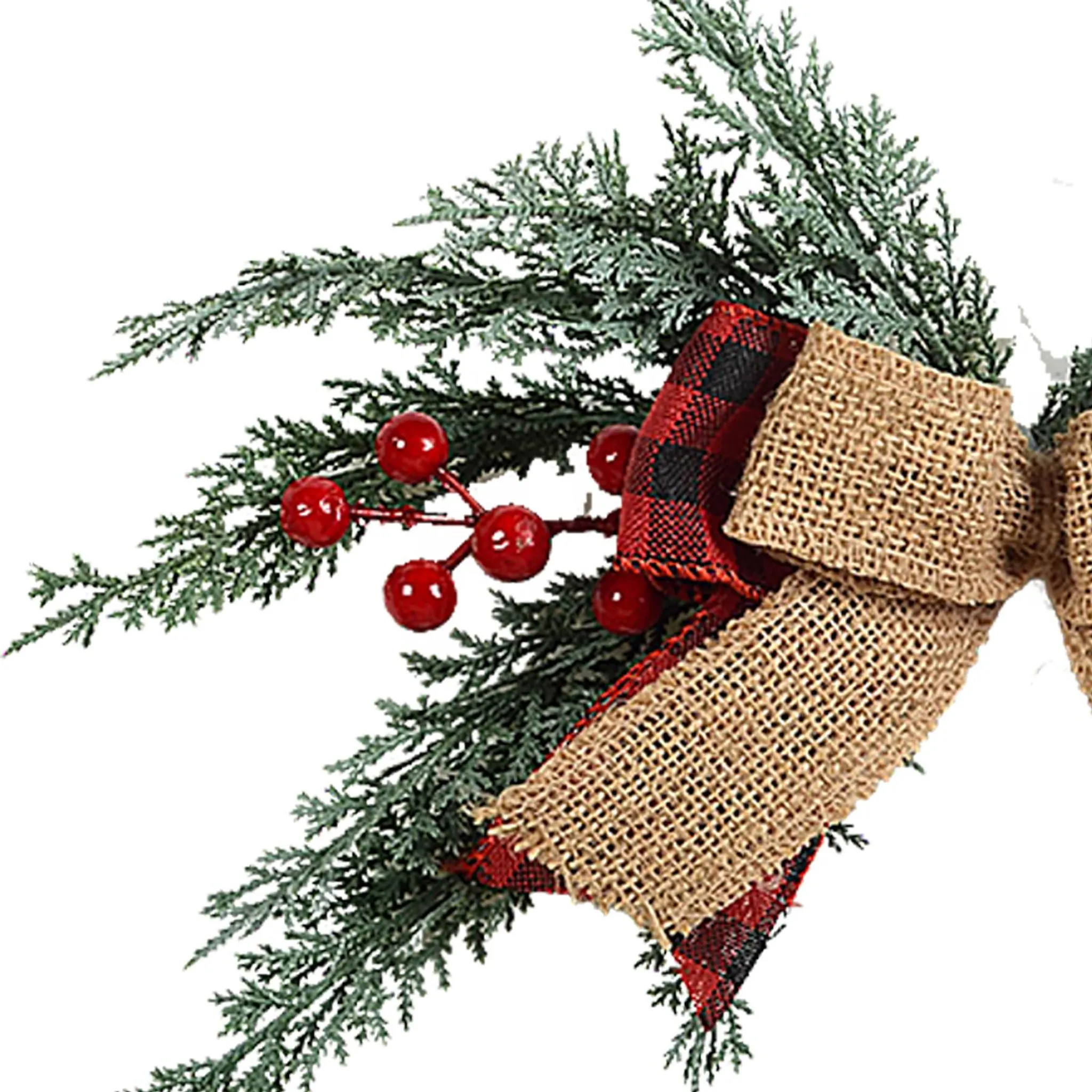 Nahaufnahme einer Weihnachtsdekoration mit grünen Zweigen, roten Beeren und einer Schleife aus Jute und Karomuster.