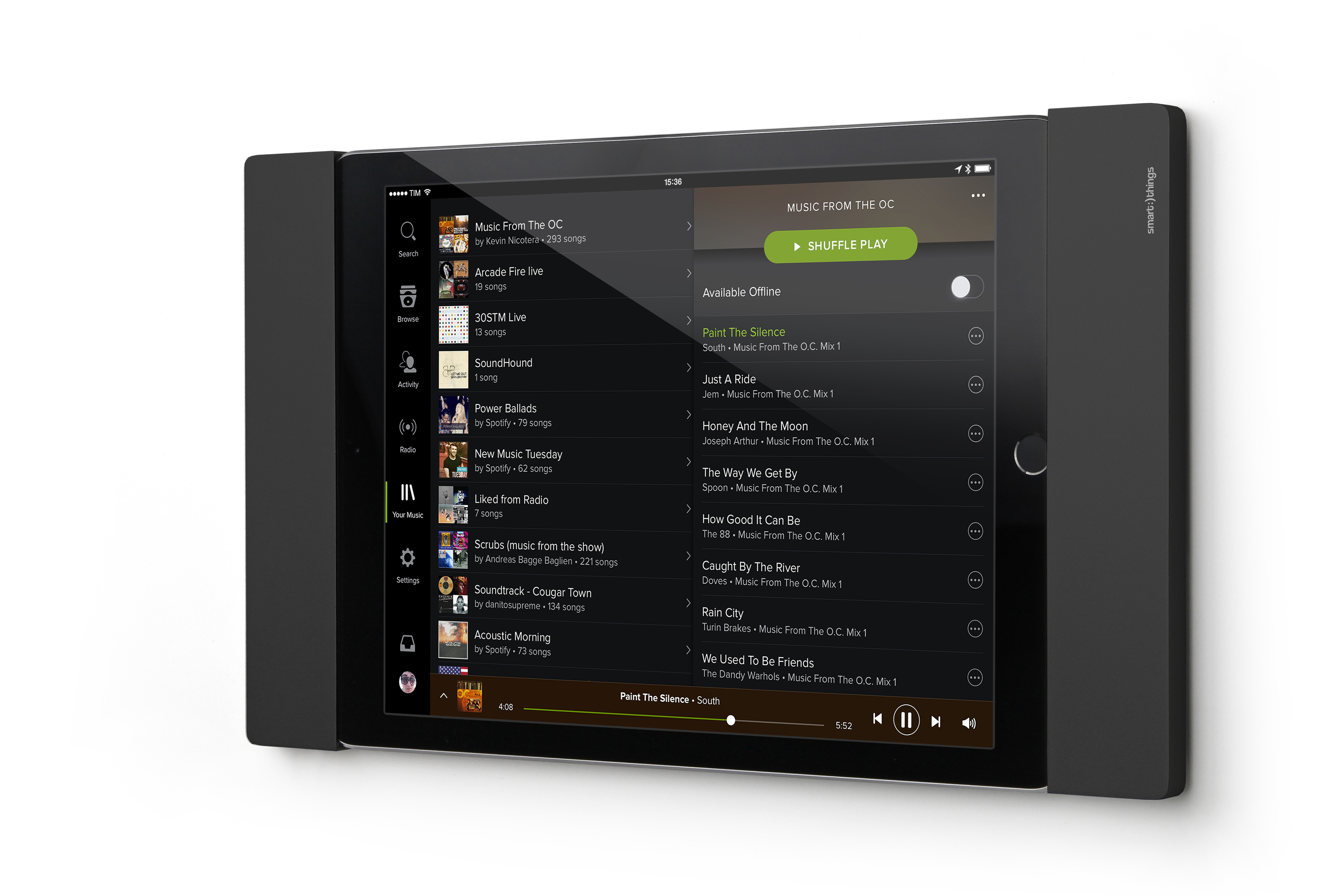 Tablet mit Musik-App. Schwarze Tablethülle rechts. Weiße Wand im Hintergrund.