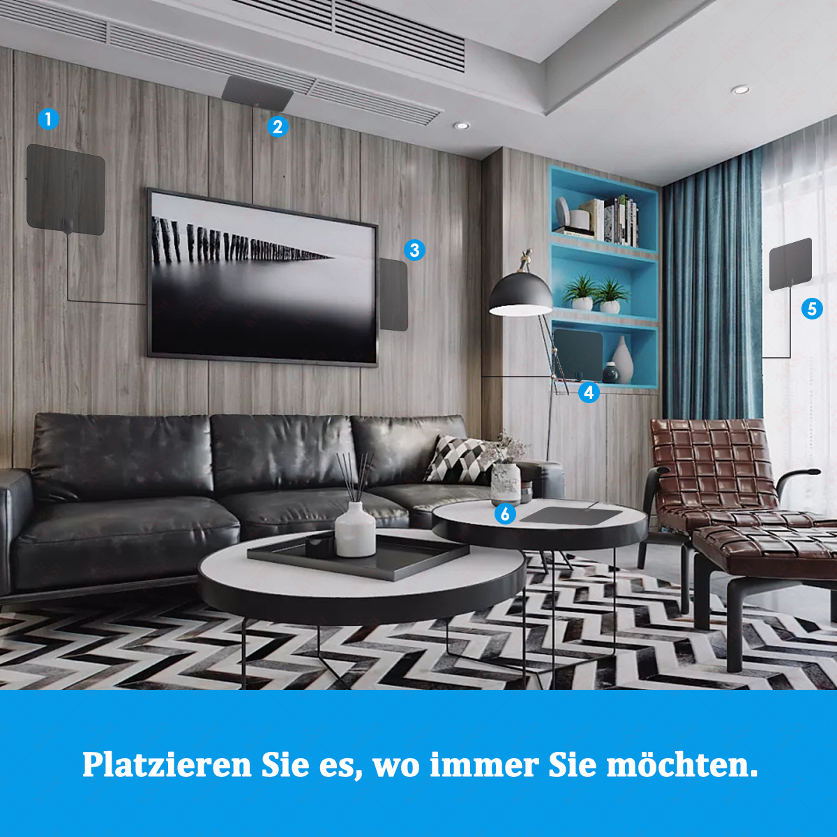 Ein modernes Wohnzimmer mit schwarzem Ledersofa, zwei Couchtischen und einem gemusterten Teppich. Ein großer Fernseher hängt an einer Wand.