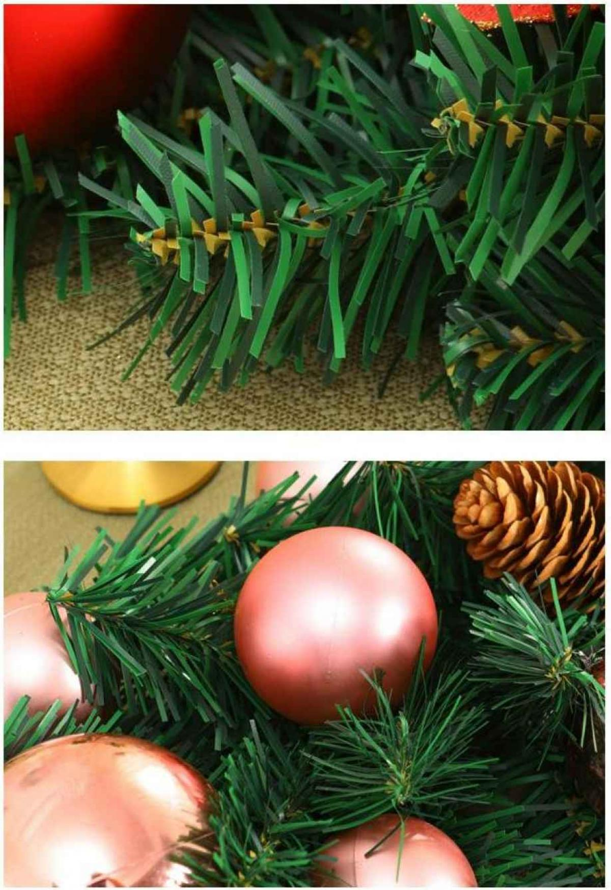 Nahaufnahme einer Weihnachtsdekoration. Rosafarbene Ornamente, grüne Nadeln und ein Tannenzapfen sind sichtbar.