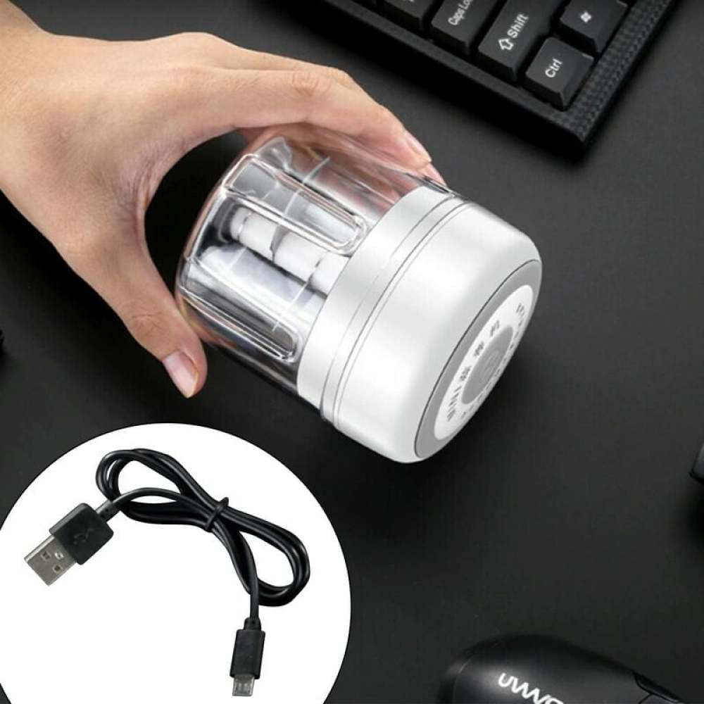 Eine Hand hält einen weißen und durchsichtigen Grinder. Ein schwarzes USB-Kabel und eine Tastatur sind sichtbar.
