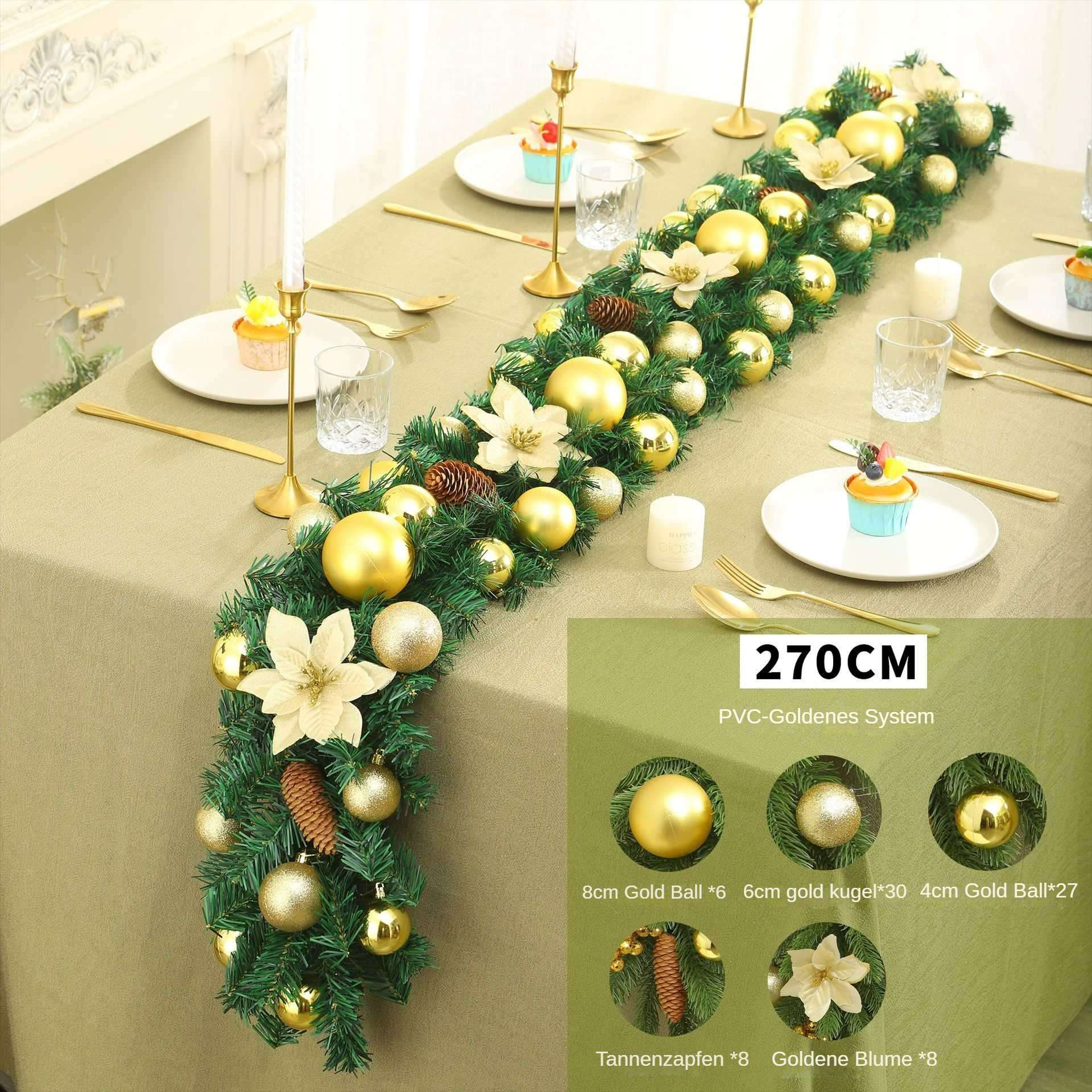 Eine Tischdekoration mit einer Weihnachts-Girlande, goldenen Kugeln, weißen Blumen und Cupcakes. Goldene Bestecke und Kerzenhalter sind vorhanden.