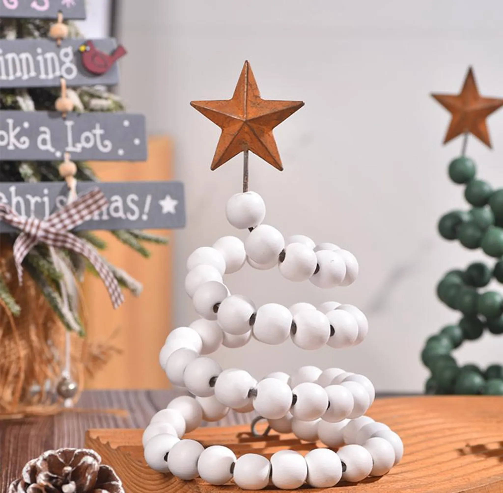 Ein dekorativer Weihnachtsbaum aus weißen Perlen mit einem Stern auf einem Holzsockel.