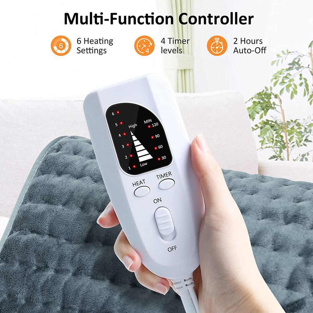 Eine Hand hält eine weiße Steuerung mit Einstellungen für Wärme und Timer. Sie ist mit einem grauen Heizkissen verbunden.