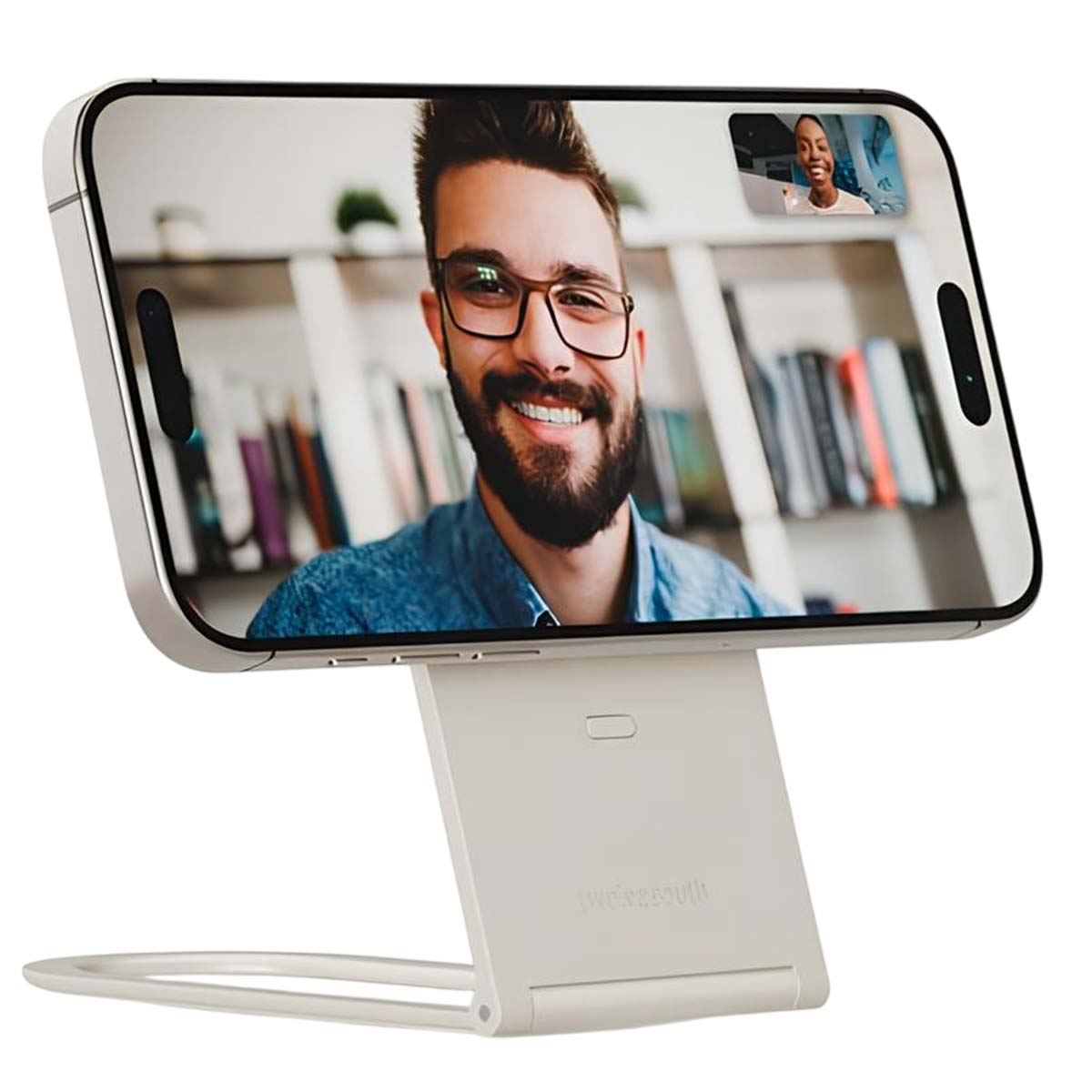 Un telefono su un supporto mostra una videochiamata. Un uomo con gli occhiali sorride. Una donna è nella piccola finestra della videochiamata.