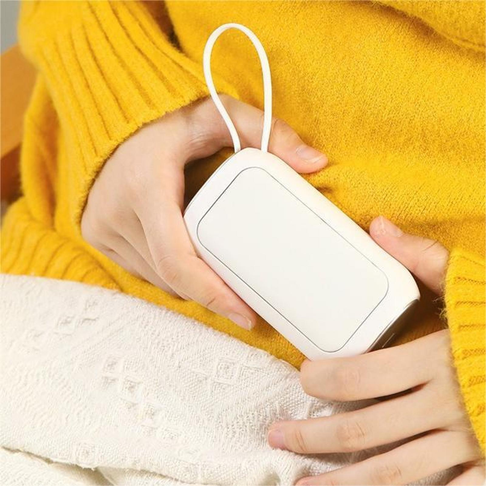 Eine Person hält einen weißen Handwärmer in ihren Händen und trägt einen gelben Pullover. Der Hintergrund ist gelb und weiß.