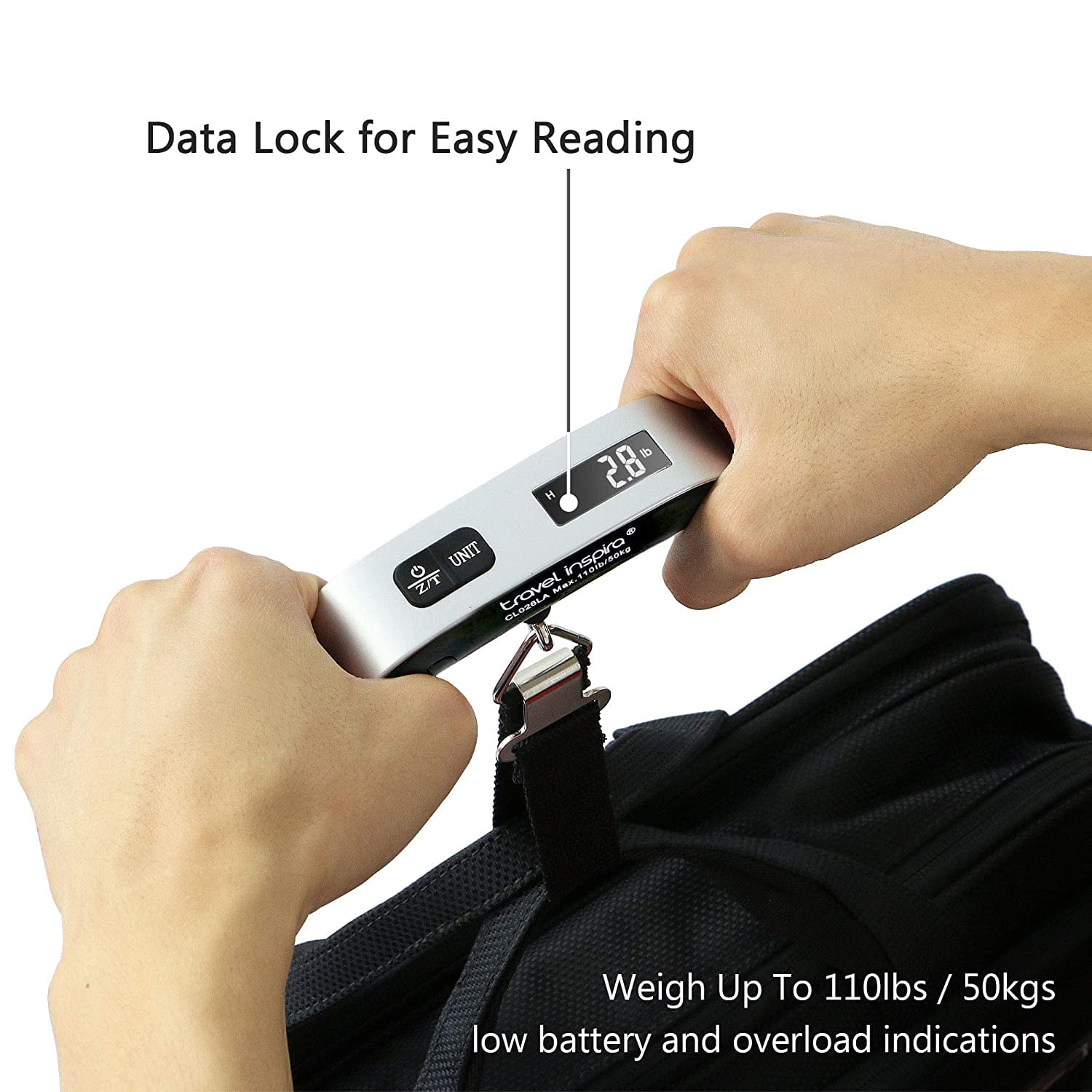Eine Person wiegt eine schwarze Tasche mit einer Digitalwaage. Die Waage zeigt 2,8 lbs an. Auf der Waage steht 'Travel Inspira'.