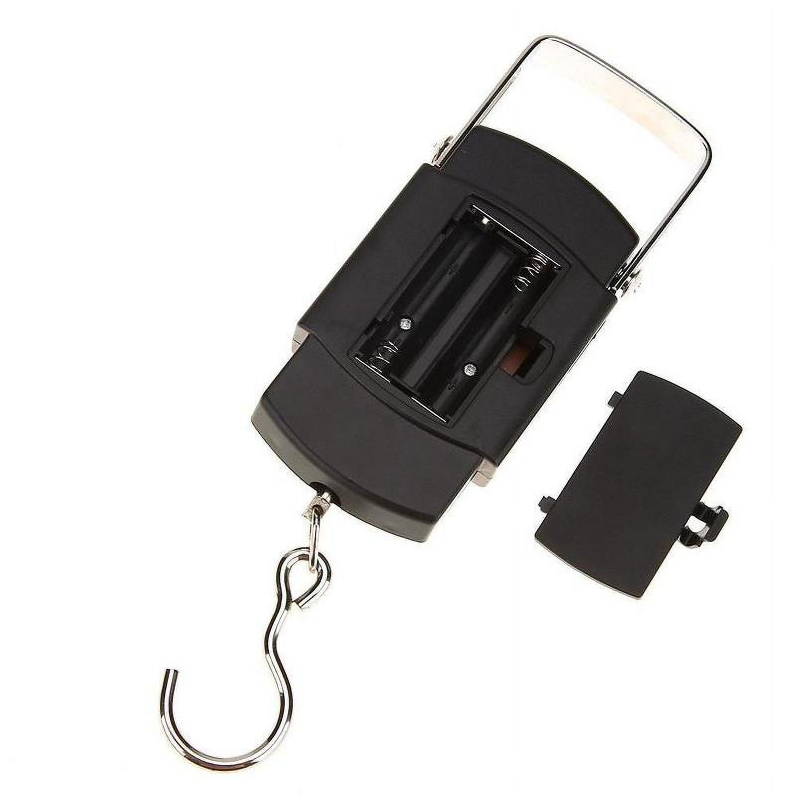 Eine schwarze Digitalwaage mit Metallhaken, Griff und offenem Batteriefach. Die Abdeckung liegt daneben.