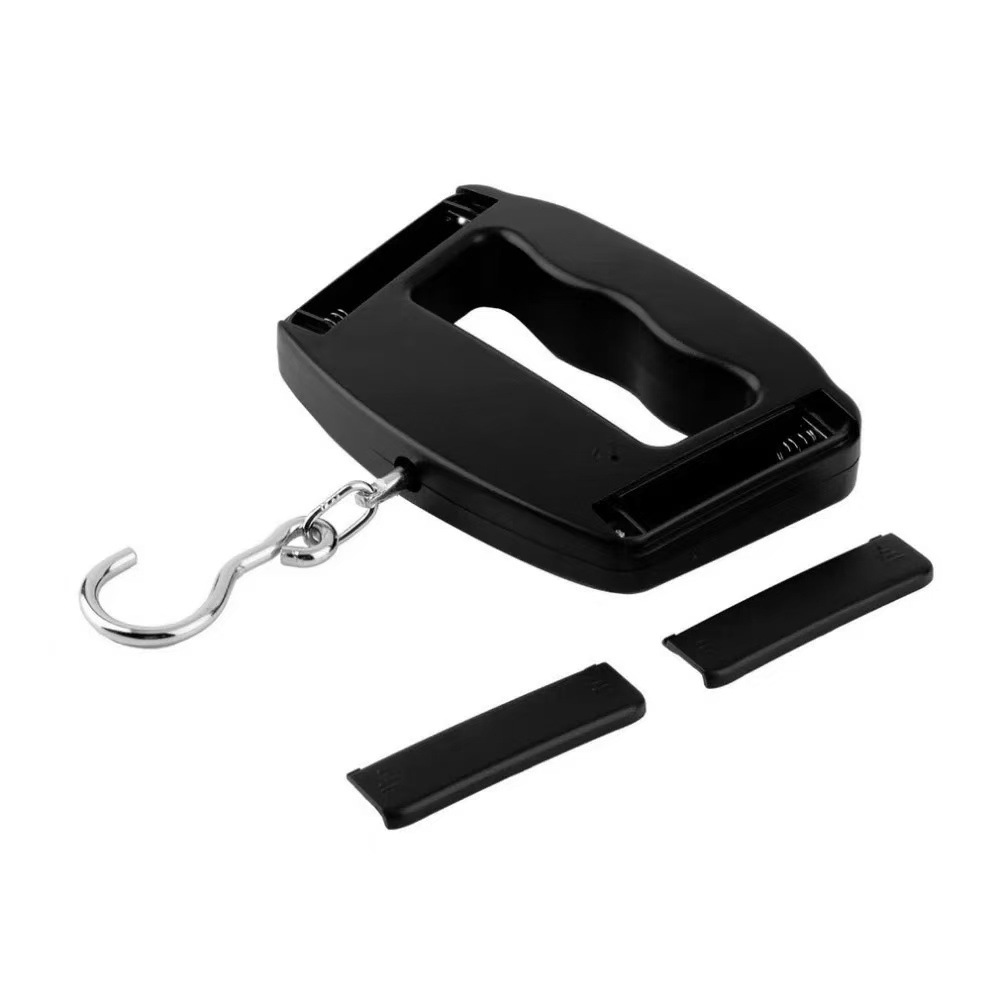 Eine schwarze digitale Hängewaage mit Griff, Haken und zwei abgenommenen Batterieabdeckungen. Isoliert auf weißem Hintergrund.