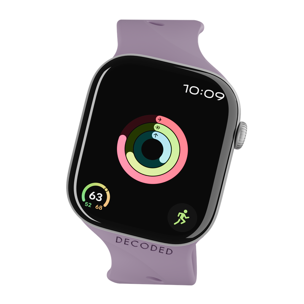 Un Apple Watch con cinturino viola, che mostra anelli di attività e l'ora 10:09 su schermo nero. 'DECODED' è stampato sul cinturino.