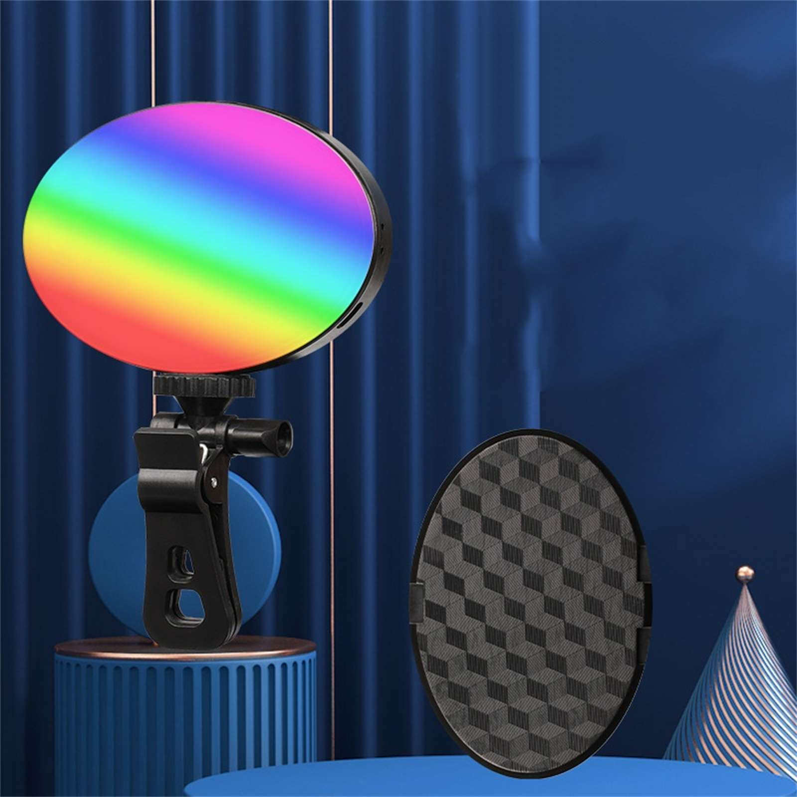 Rundes LED-Licht mit Regenbogenfarben, schwarzem Clip und gemustertem Reflektor. Blauer Hintergrund mit dekorativen Elementen.