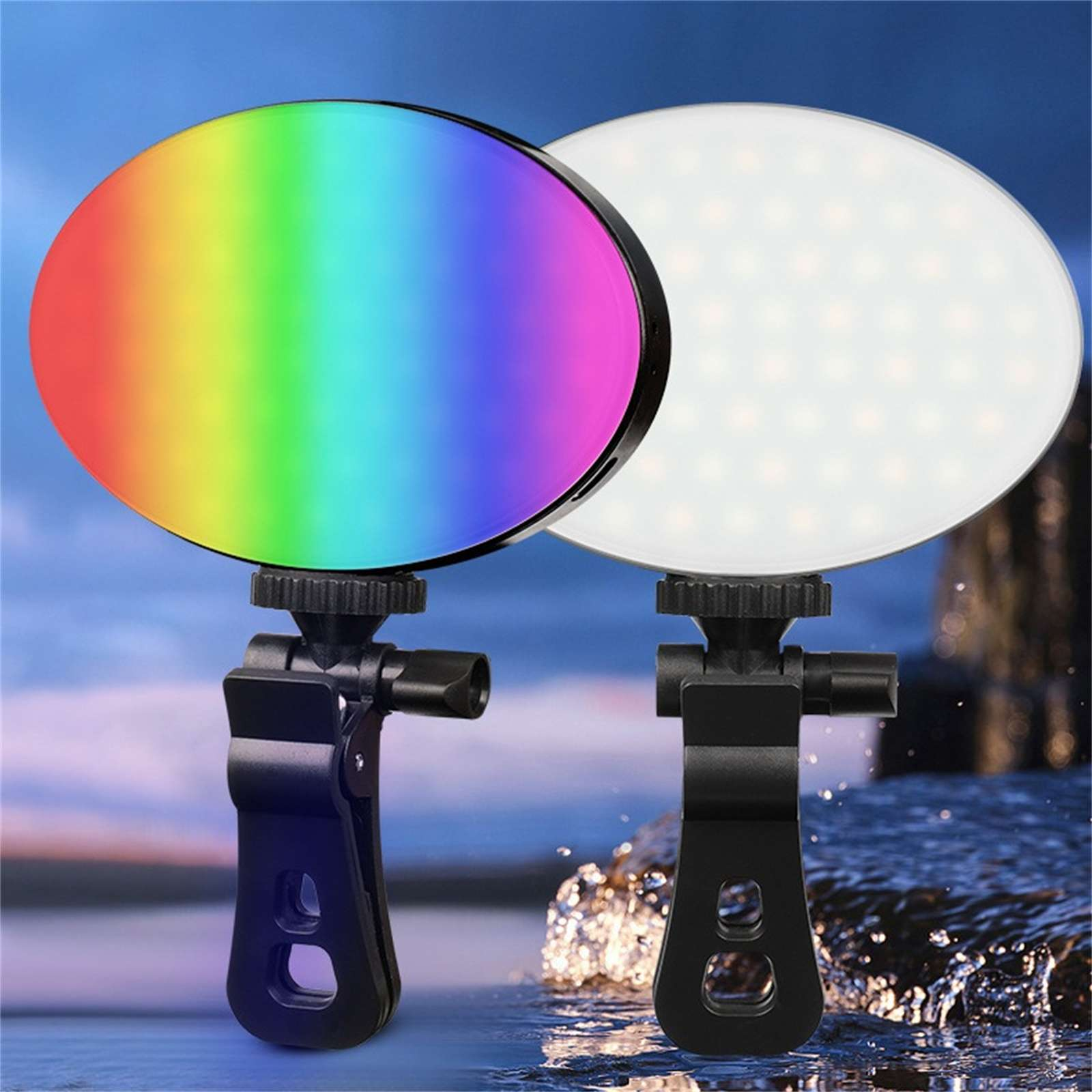 Zwei LED-Leuchten, eine Regenbogenfarben, eine weiß, jeweils mit schwarzer Cliphalterung. Hintergrund zeigt Wasser und blauen Himmel.