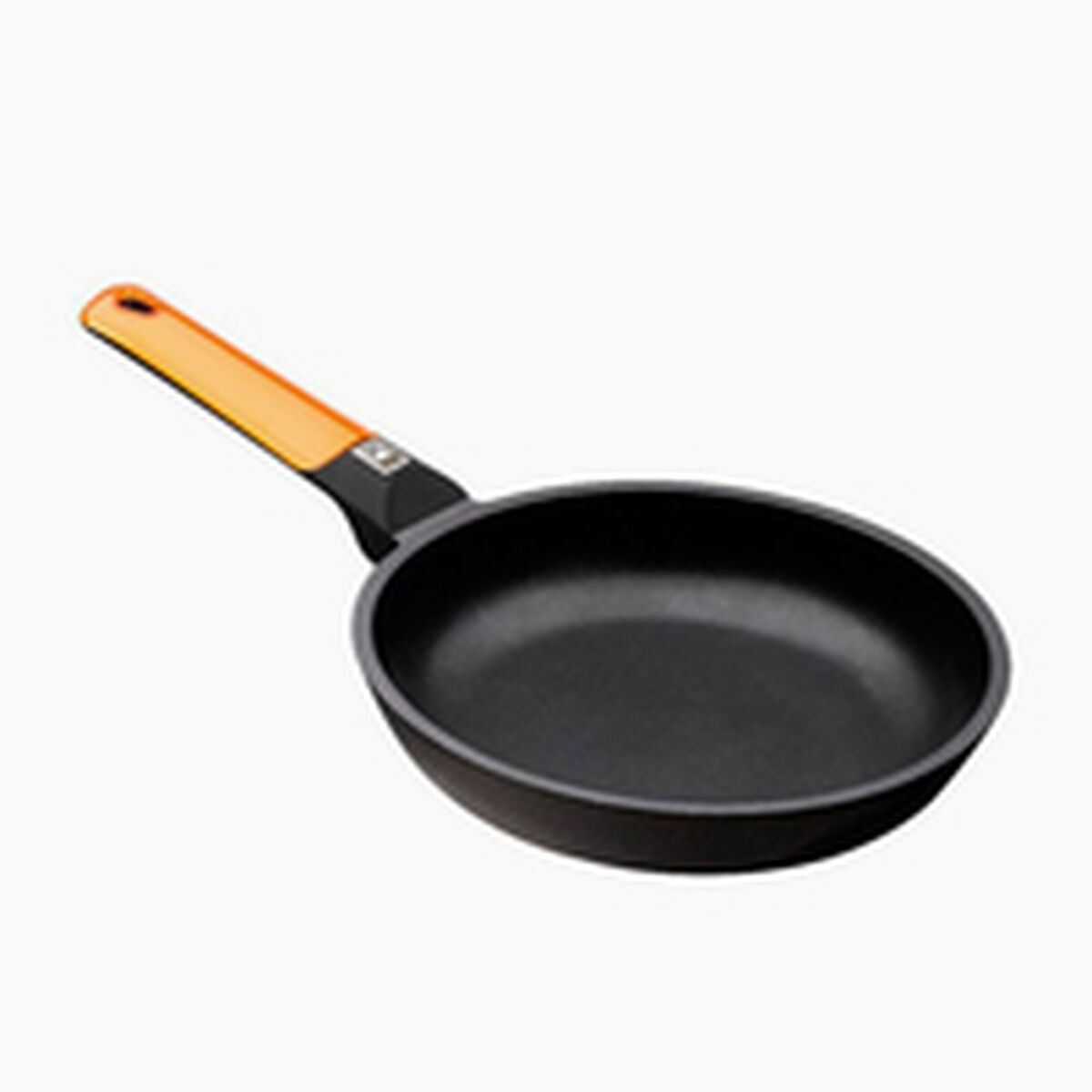 Eine schwarze Bratpfanne mit orangefarbenem Griff vor weißem Hintergrund.