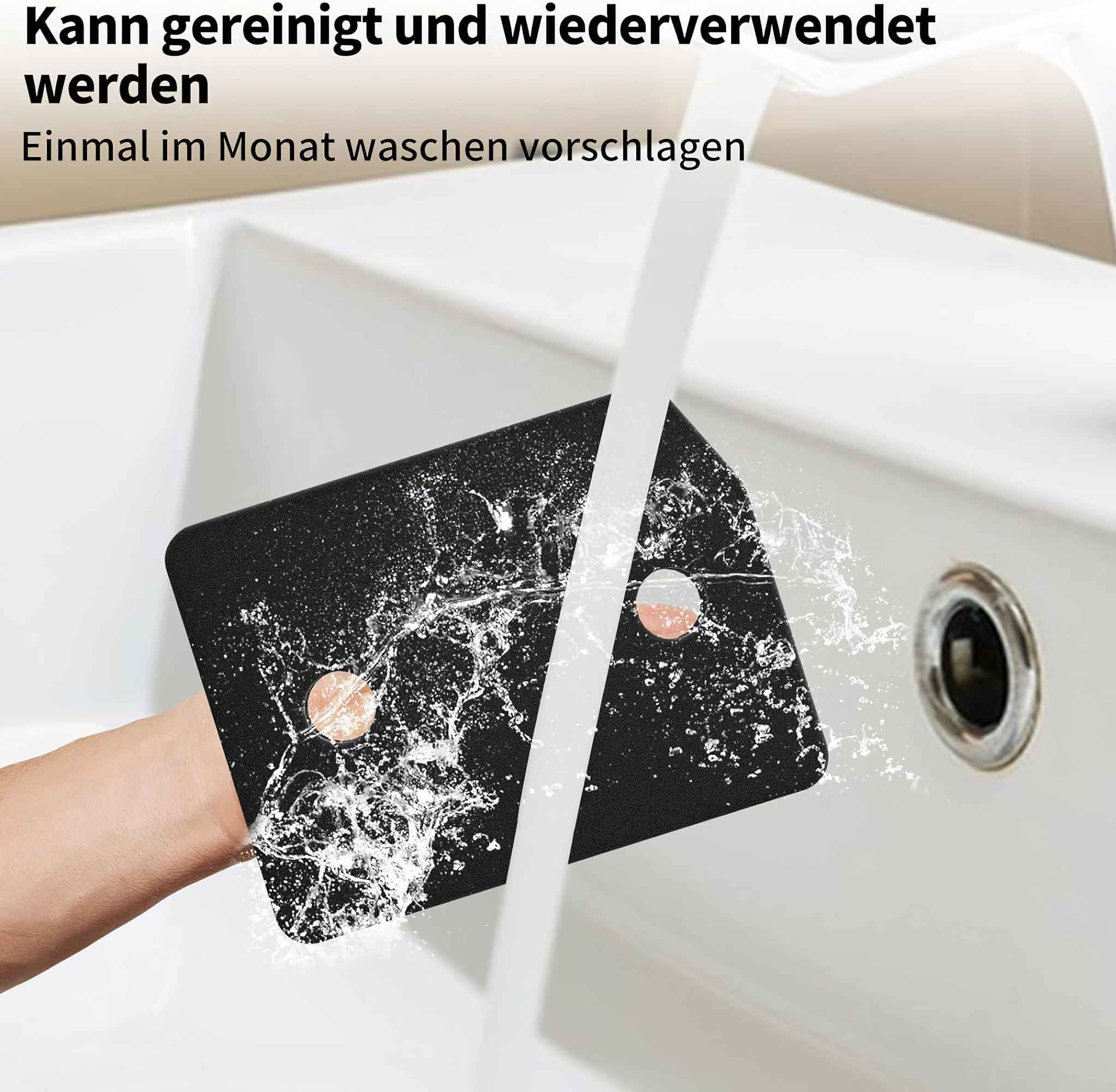 Ein schwarzer Schwamm wird in einem weißen Waschbecken mit Wasser gewaschen. Er hat zwei rosa Kreise. Wasser spritzt herum.