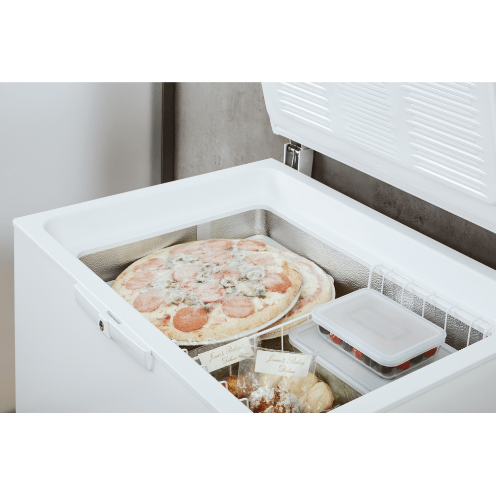 Congelatore bianco aperto con pizza, contenitori di cibo e prodotti da forno. Il coperchio del congelatore è aperto. Gli articoli sono congelati.