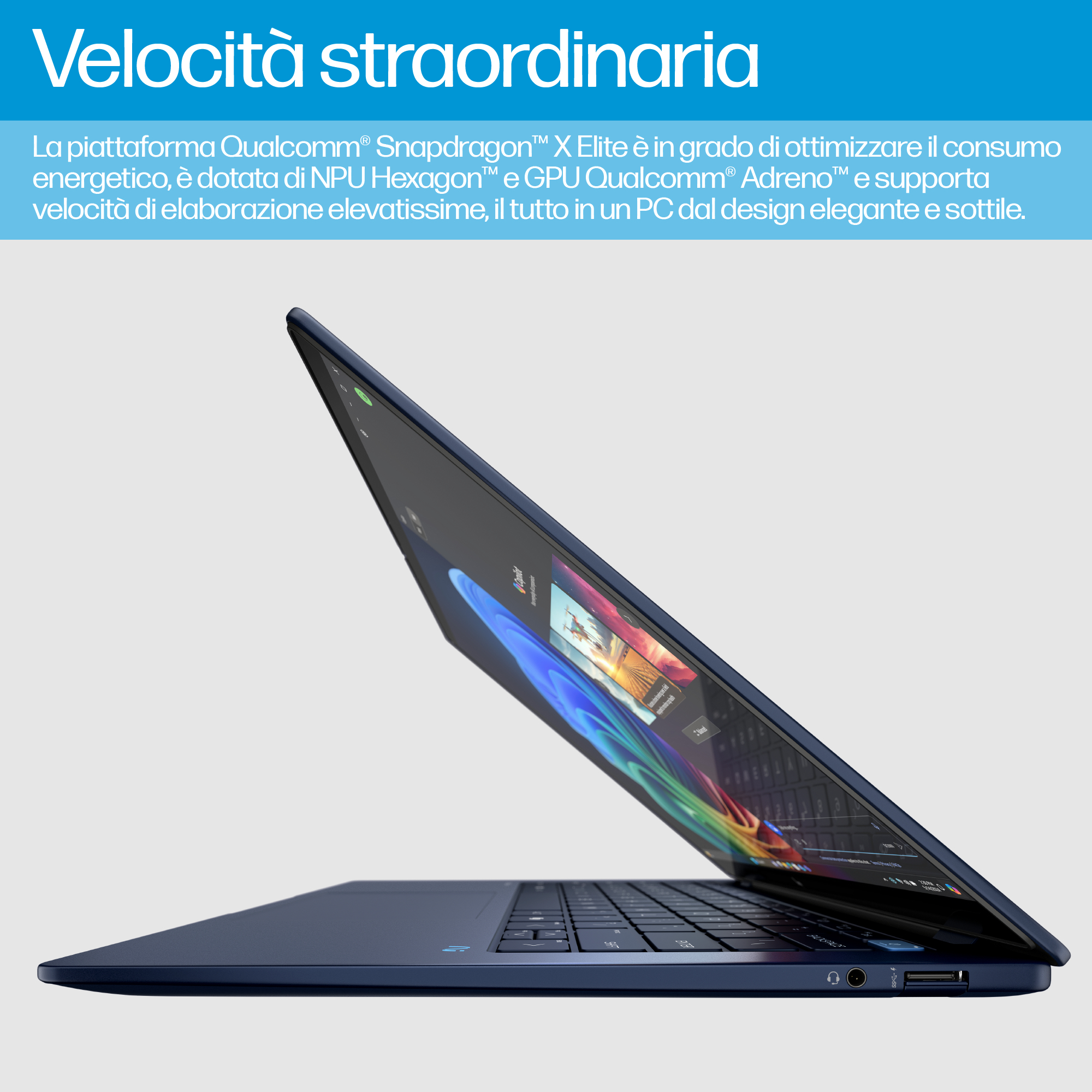Un portátil azul oscuro está abierto sobre una superficie blanca. La pantalla muestra una imagen colorida.