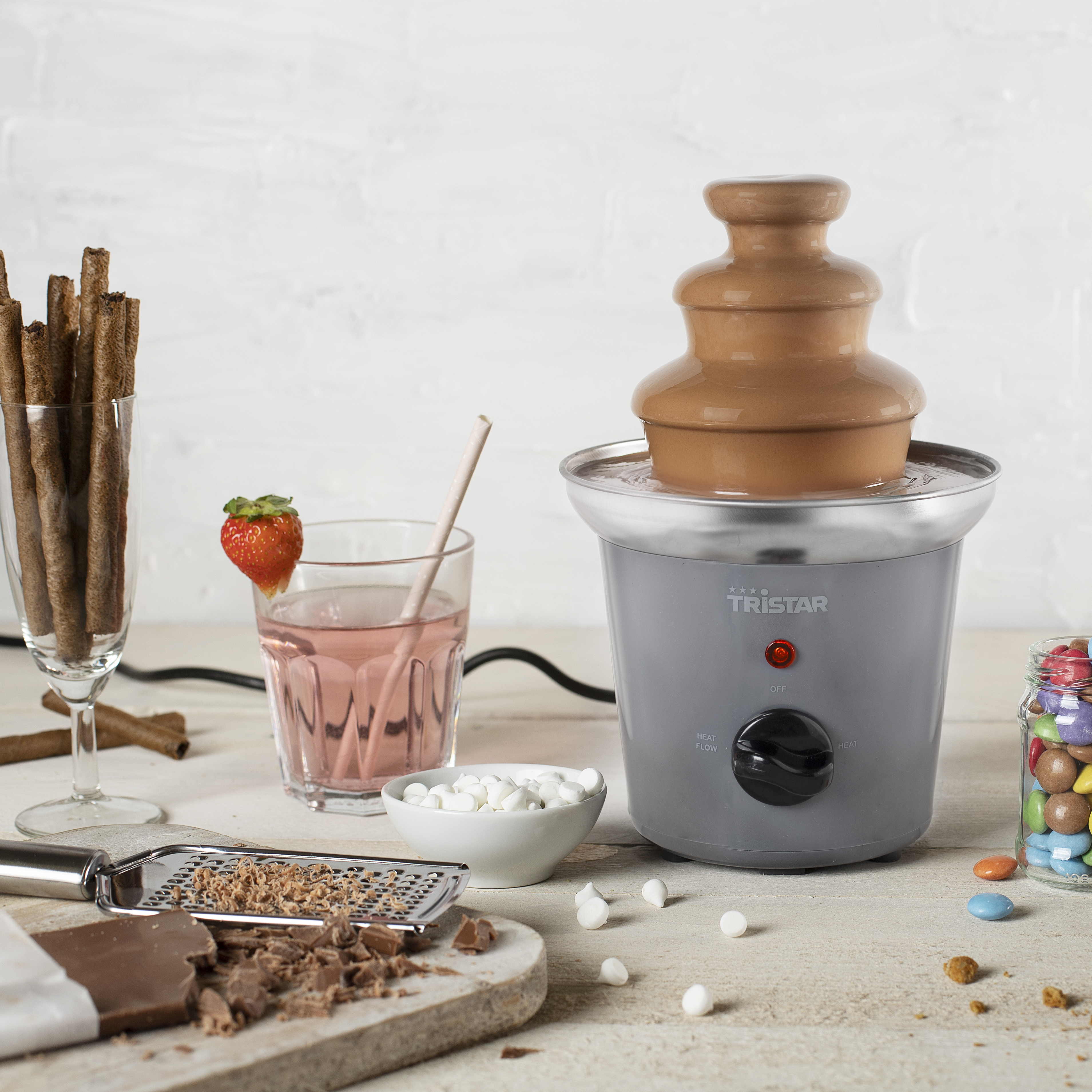 Schokoladenbrunnen mit Snacks: Waffeln, Getränk mit Erdbeere, Marshmallows, Schokolade und Süßigkeiten.