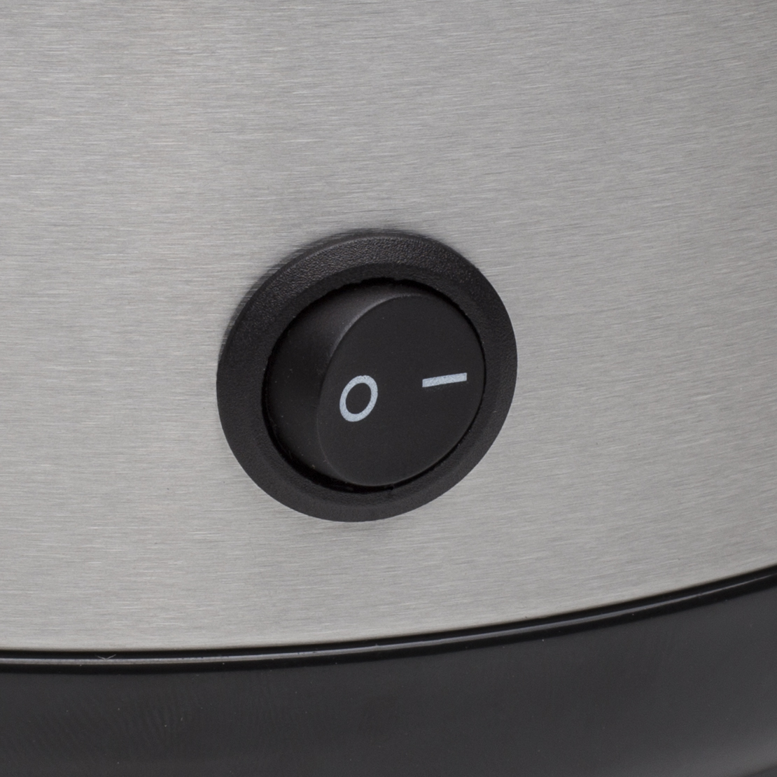 Zbliżenie czarnego przycisku zasilania z białymi symbolami na metalowej powierzchni. Przycisk jest okrągły z 'O' i kreską.