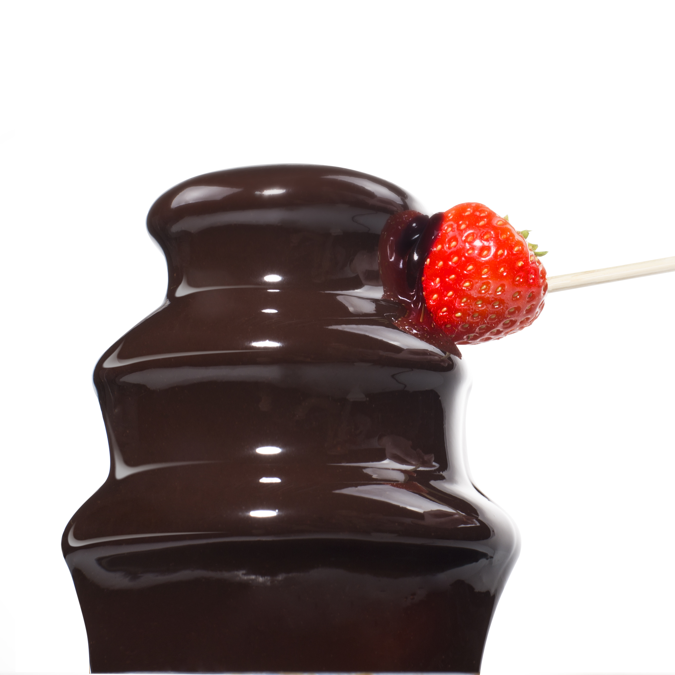 Una fuente de chocolate con una fresa roja en un palito. El chocolate fluye. Fondo blanco.