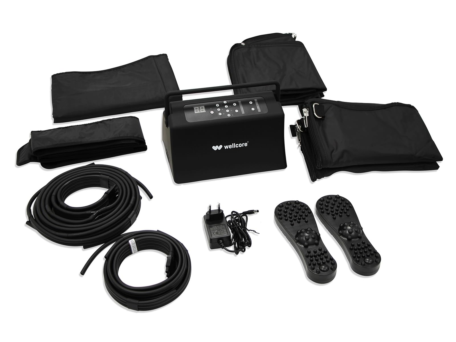 Un kit de dispositivo Wellcore. Contiene una unidad de control negra, bolsas negras, tubos, masajeadores de pies y un adaptador, todo sobre fondo blanco.