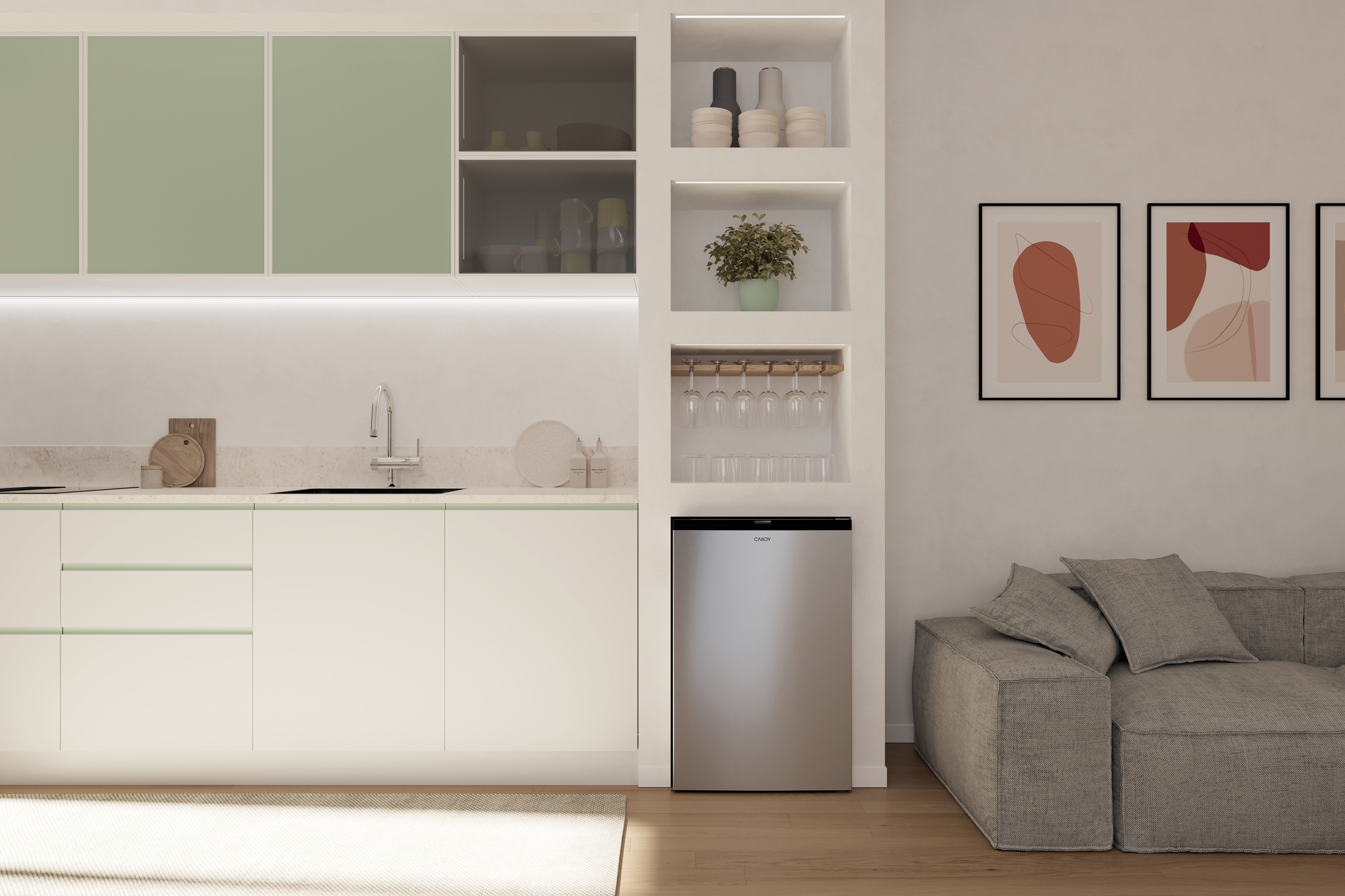 Moderne Küche mit weißen Schränken, silbernem Kühlschrank und abstrakter Kunst. Rechts ein graues Sofa.