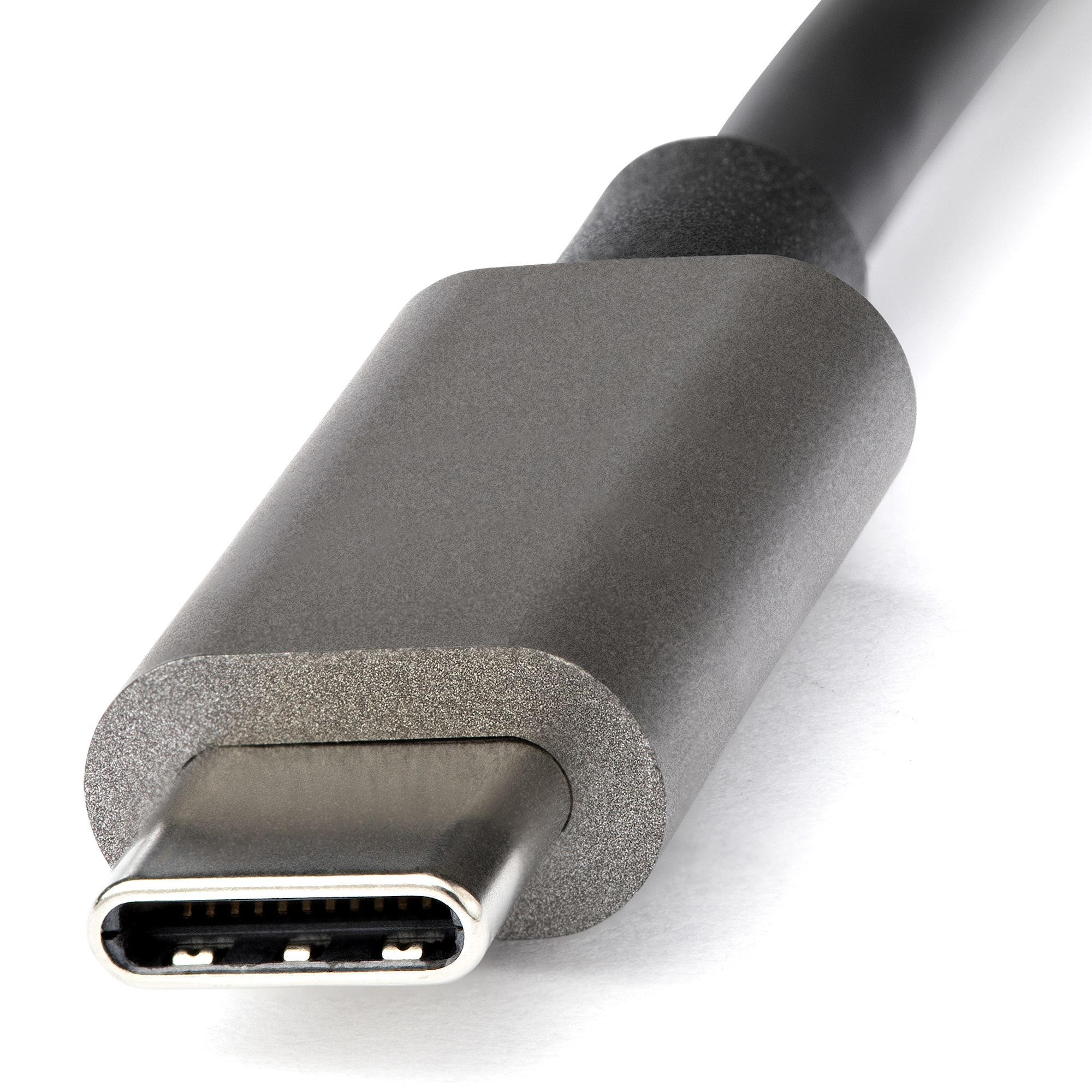 Primer plano de un conector de cable USB-C. El extremo metálico tiene pequeños pines. El cuerpo es gris, con un cable negro.