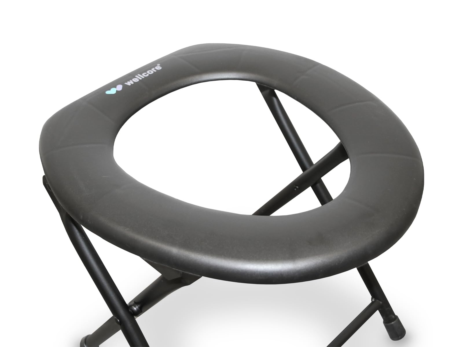 Un asiento de orinal portátil gris con patas negras, el asiento es redondo con un agujero en el medio. La marca es wellcore.