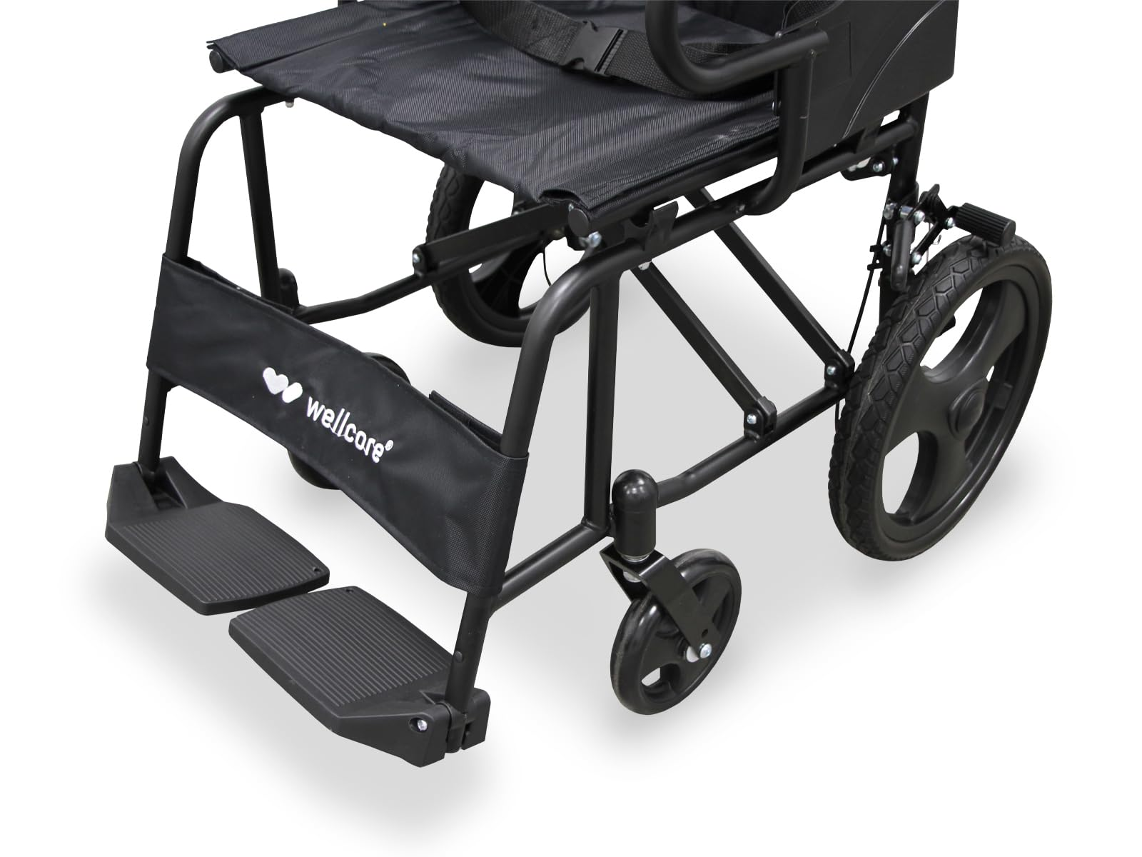 Una silla de ruedas negra con reposapiés y ruedas pequeñas. El marco es negro. El asiento es de tela negra.