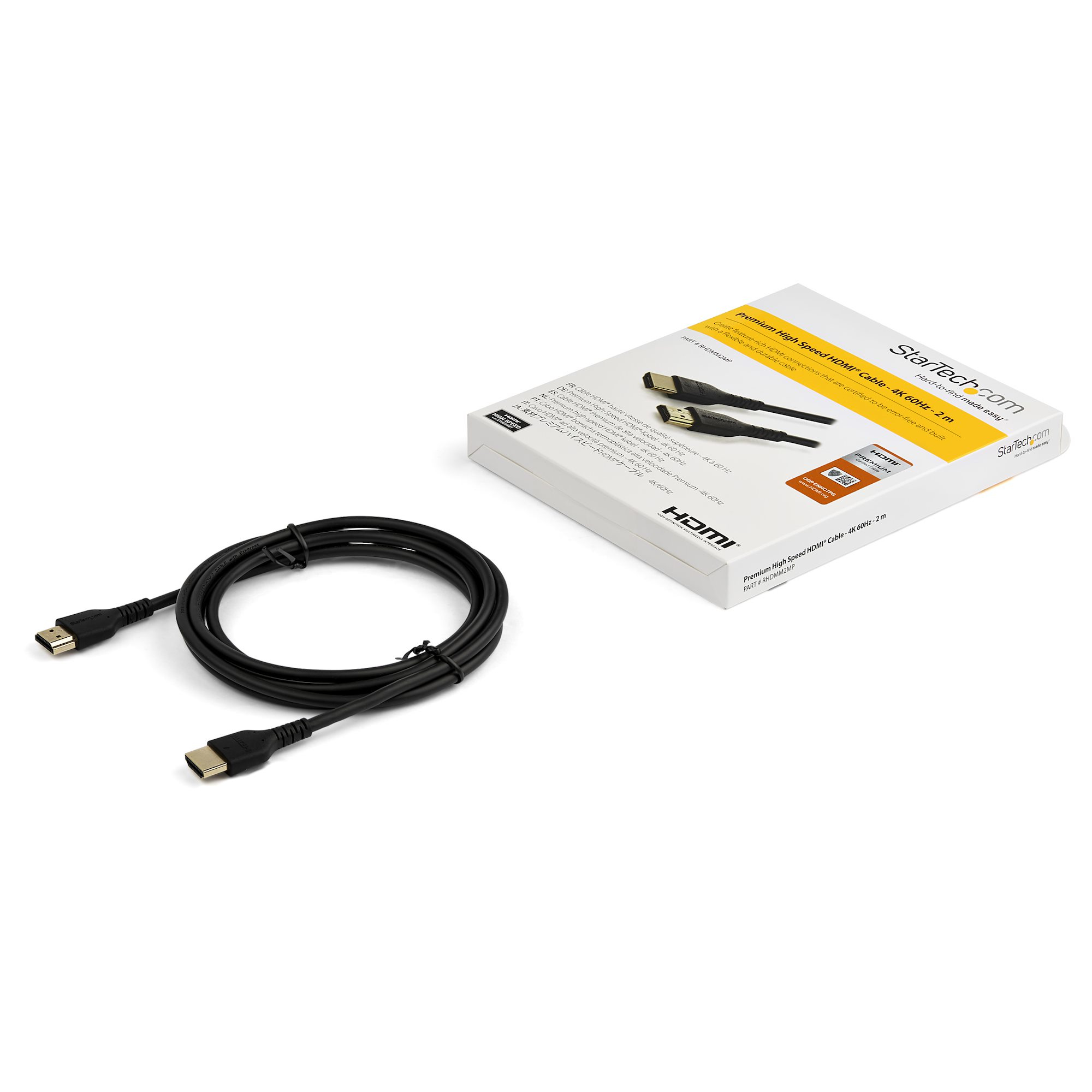 Un câble HDMI noir et une boîte blanche sur une surface blanche. La boîte contient du texte et des images.