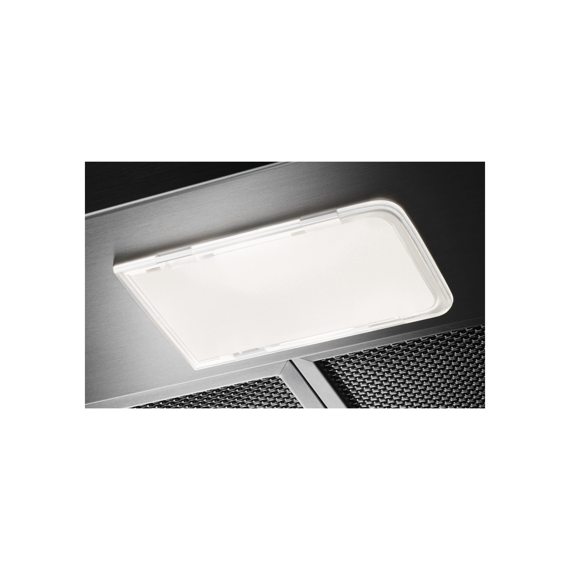 Zbliżenie okapu kuchennego z prostokątną oprawą oświetleniową i metalowym filtrem siatkowym.