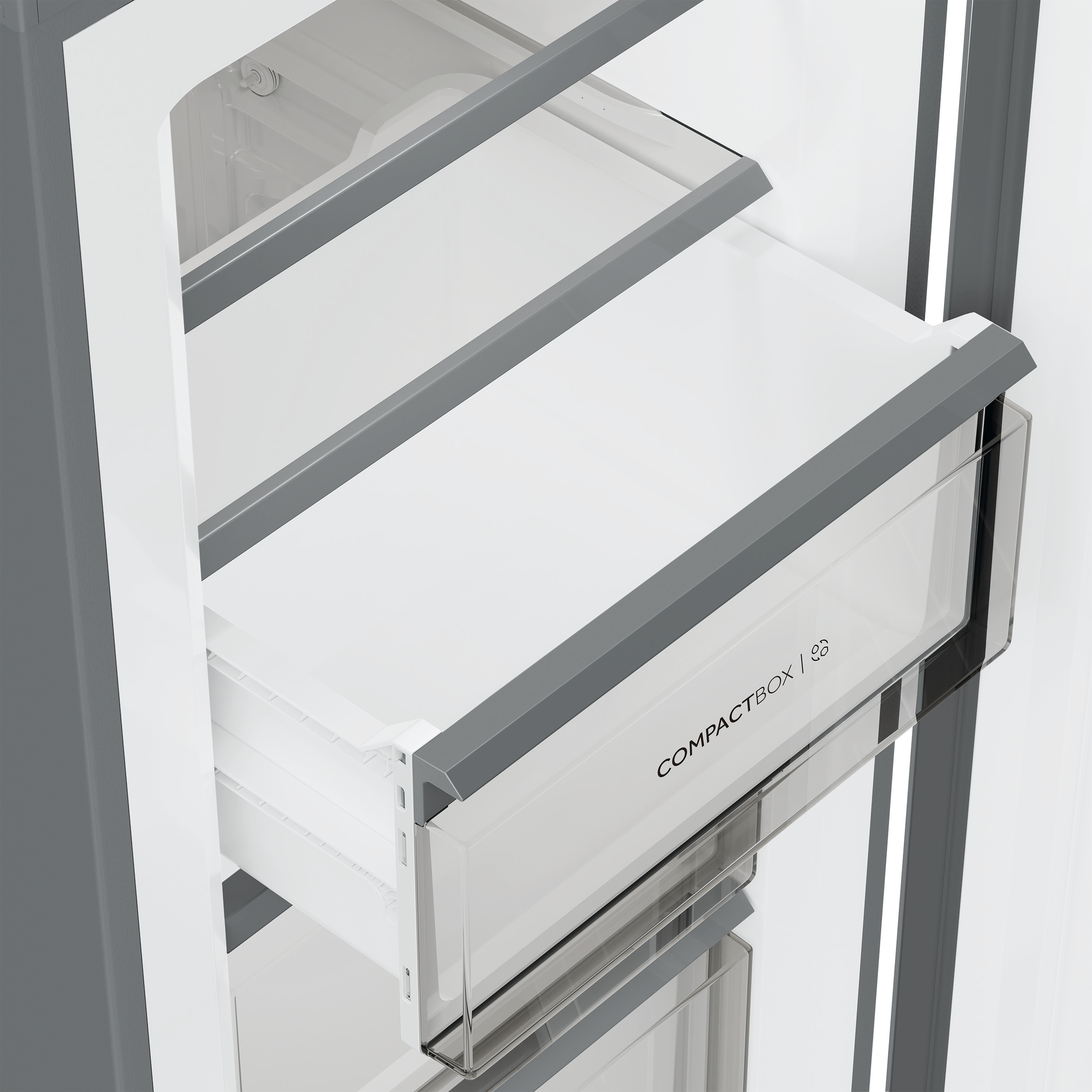 Open koelkast met een lade uitgetrokken. Wit interieur, grijze accenten en een transparante lade met het label 'COMPACTBOX'.