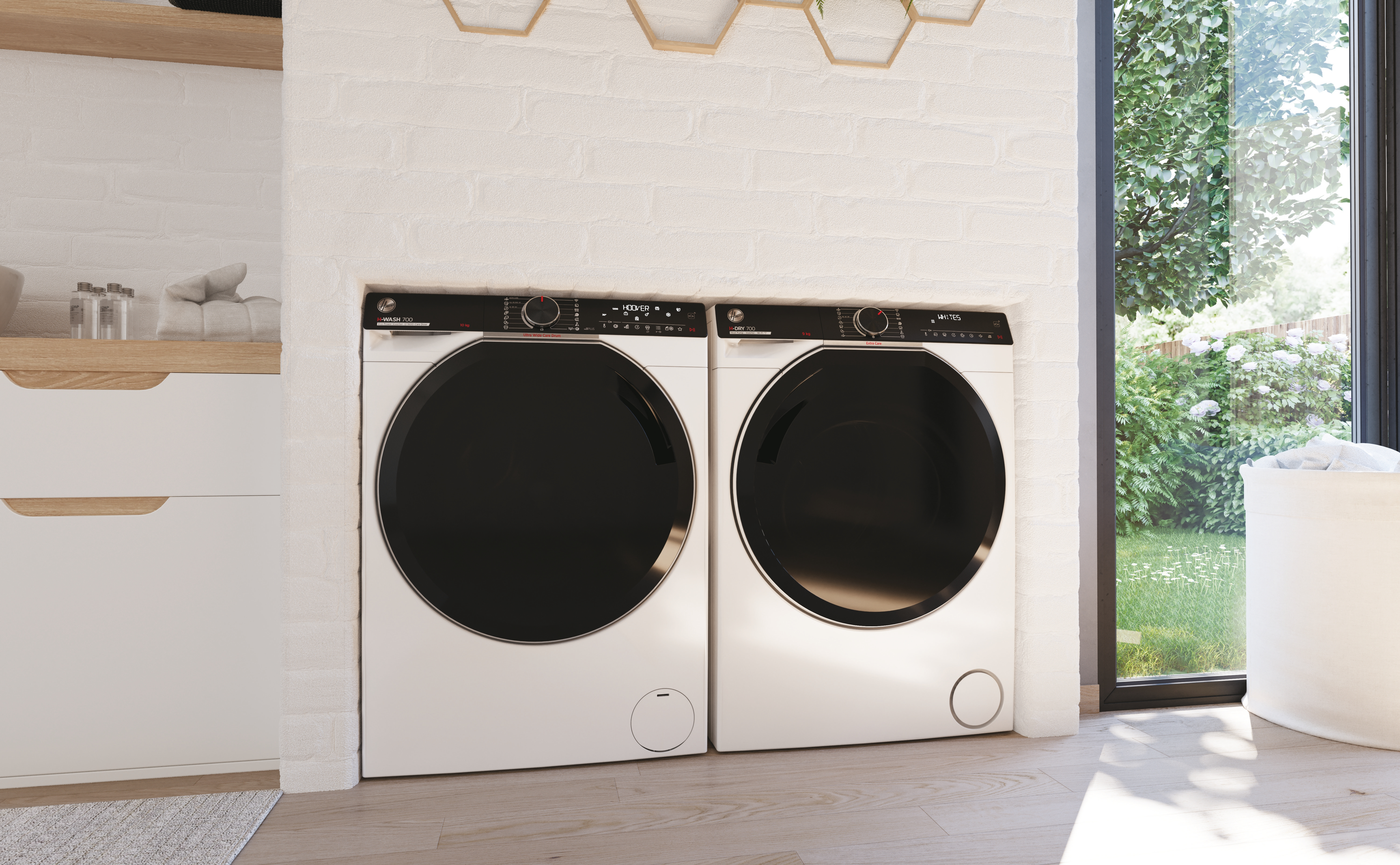 Due lavatrici bianche con porte nere si trovano in una lavanderia. Una finestra mostra un giardino.