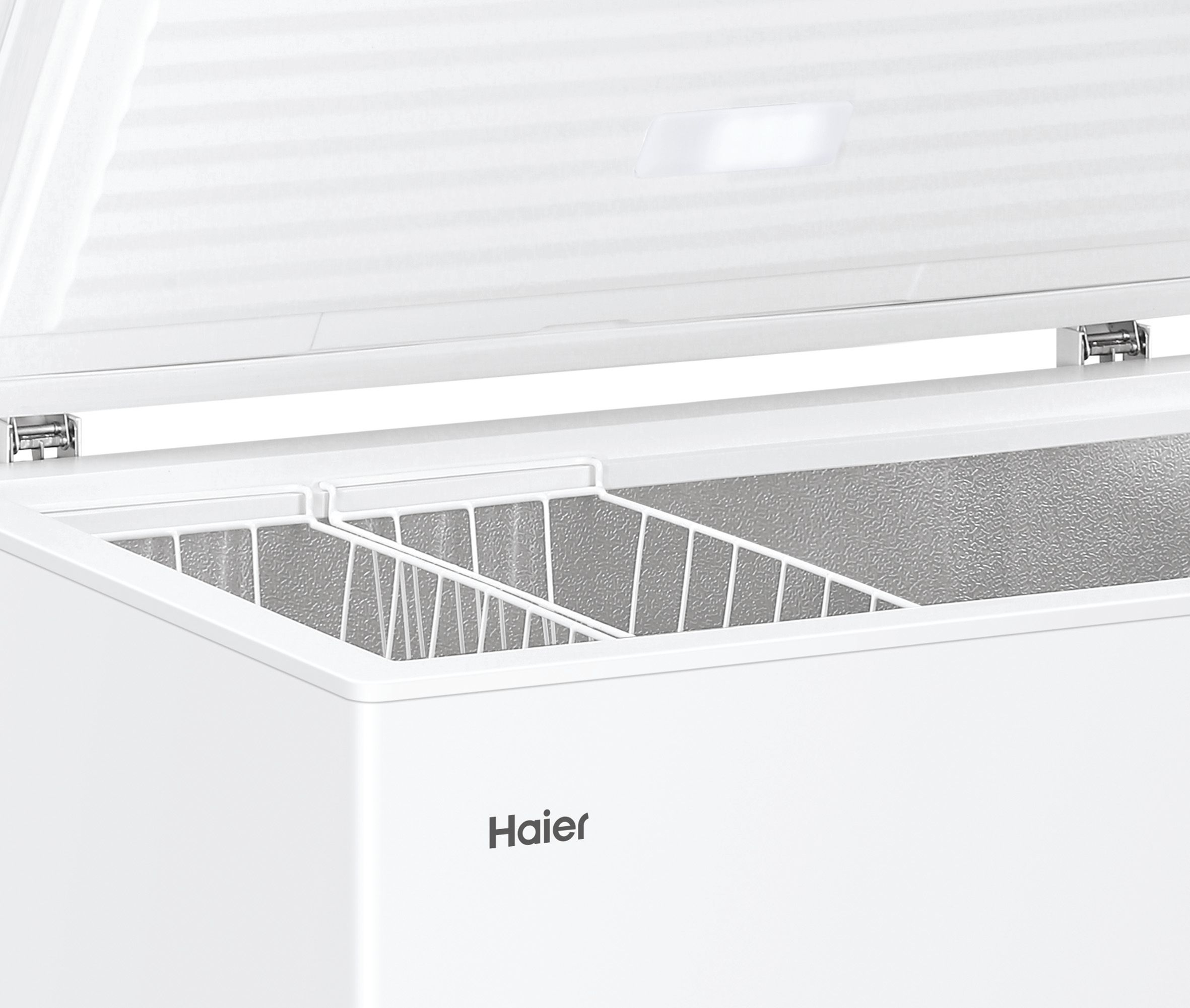 Congelatore bianco aperto con logo Haier. L'interno mostra cestelli in filo metallico. Il coperchio è aperto, rivelando l'interno.