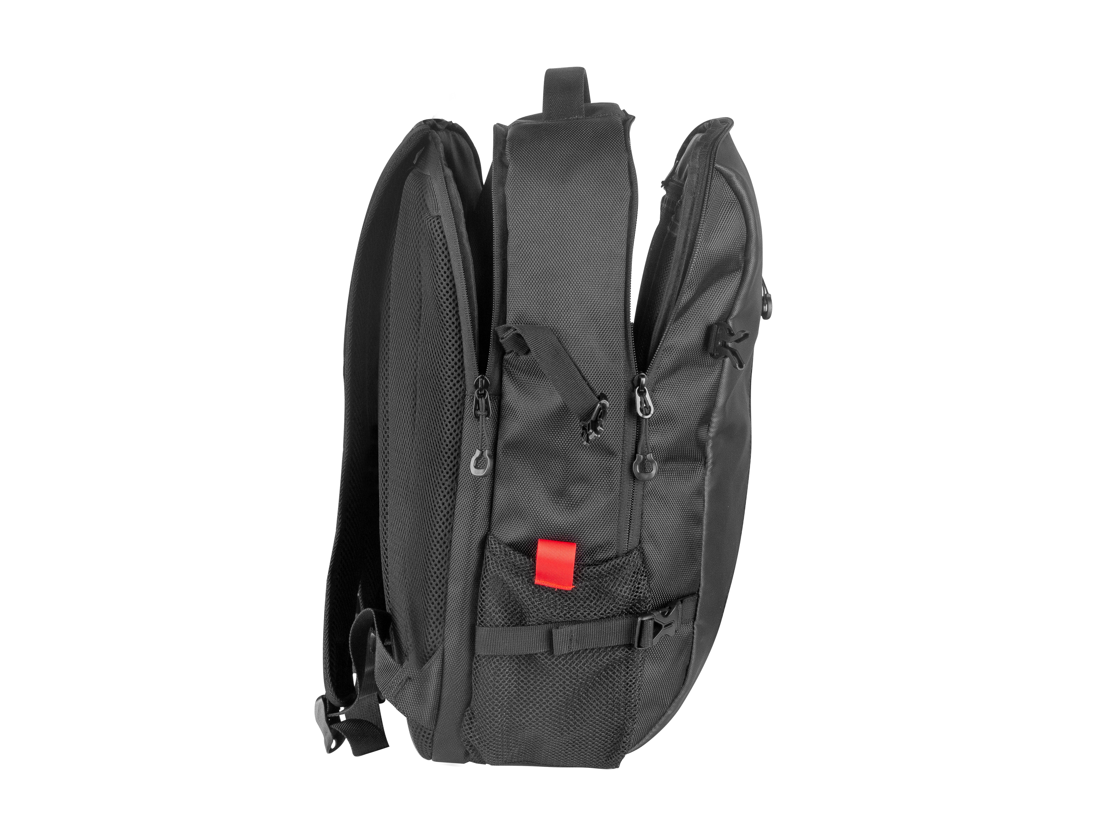 Una mochila negra con múltiples compartimentos se muestra desde una vista lateral. Tiene cremalleras, una etiqueta roja y correas.
