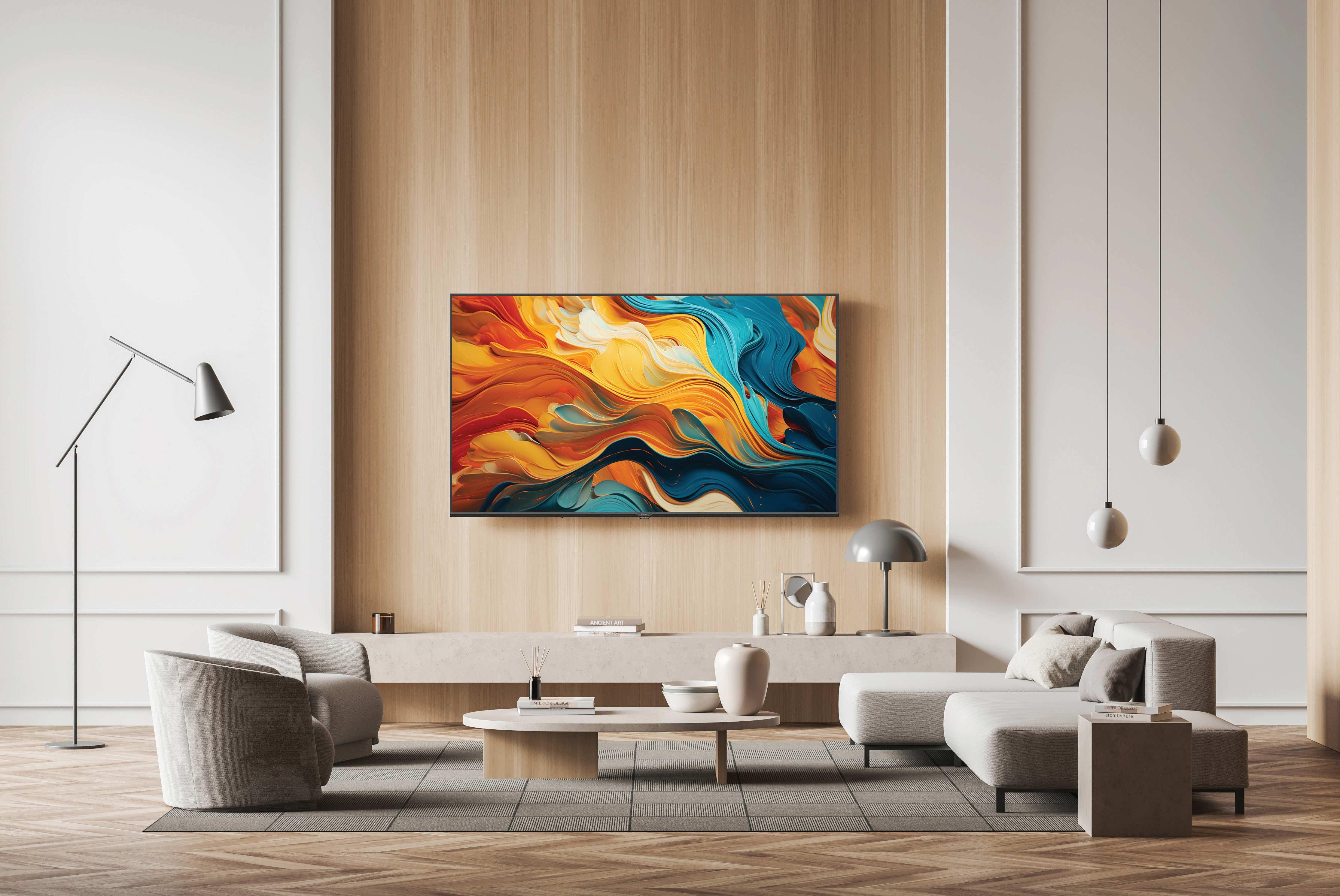 Salón con un gran televisor que muestra arte colorido. Hay dos sofás, una mesa de centro y lámparas.