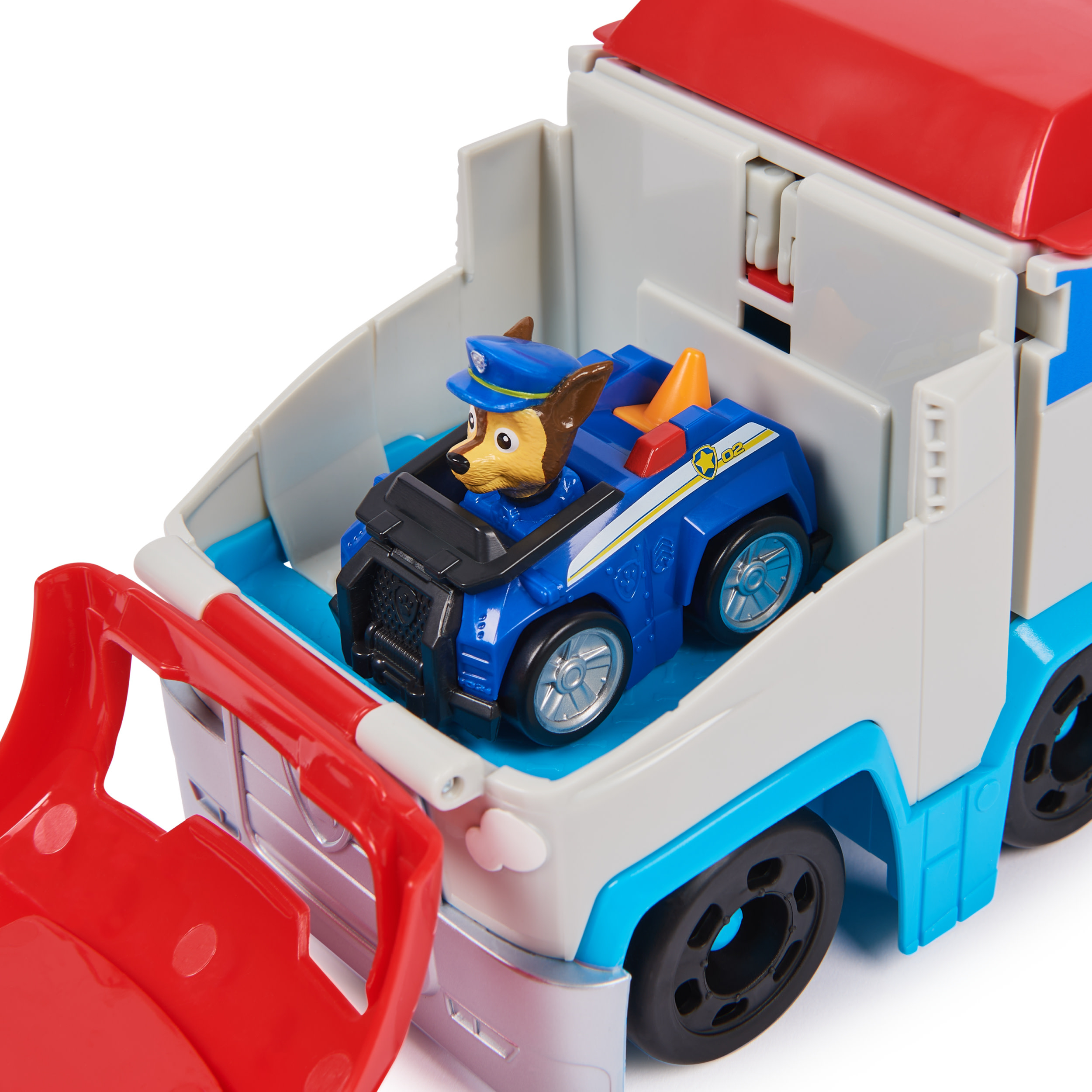 Un camión de juguete con un coche de policía azul dentro. Chase, el perro, está en el coche de policía. El camión es rojo, blanco y azul.