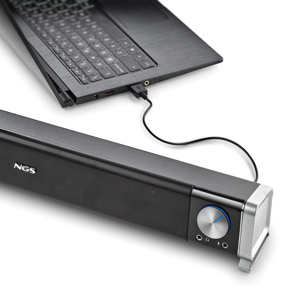 Un laptop collegato a una soundbar nera tramite un cavo USB. La soundbar ha una manopola del volume e il marchio NGS.