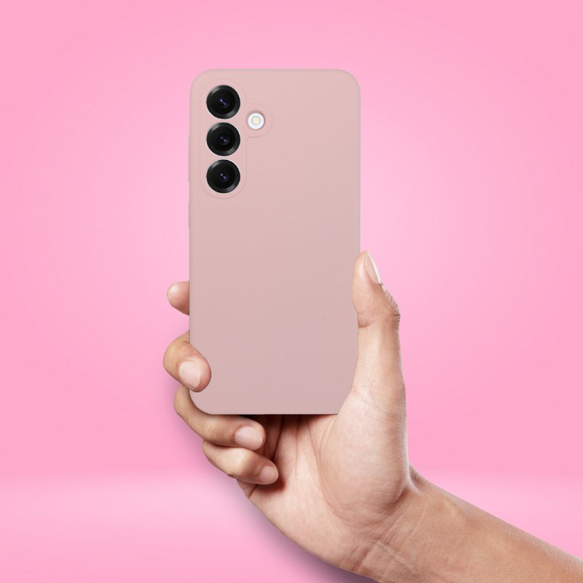 Eine Hand hält ein rosa Handy. Das Handy hat drei Kameralinsen. Der Hintergrund ist einfarbig rosa.
