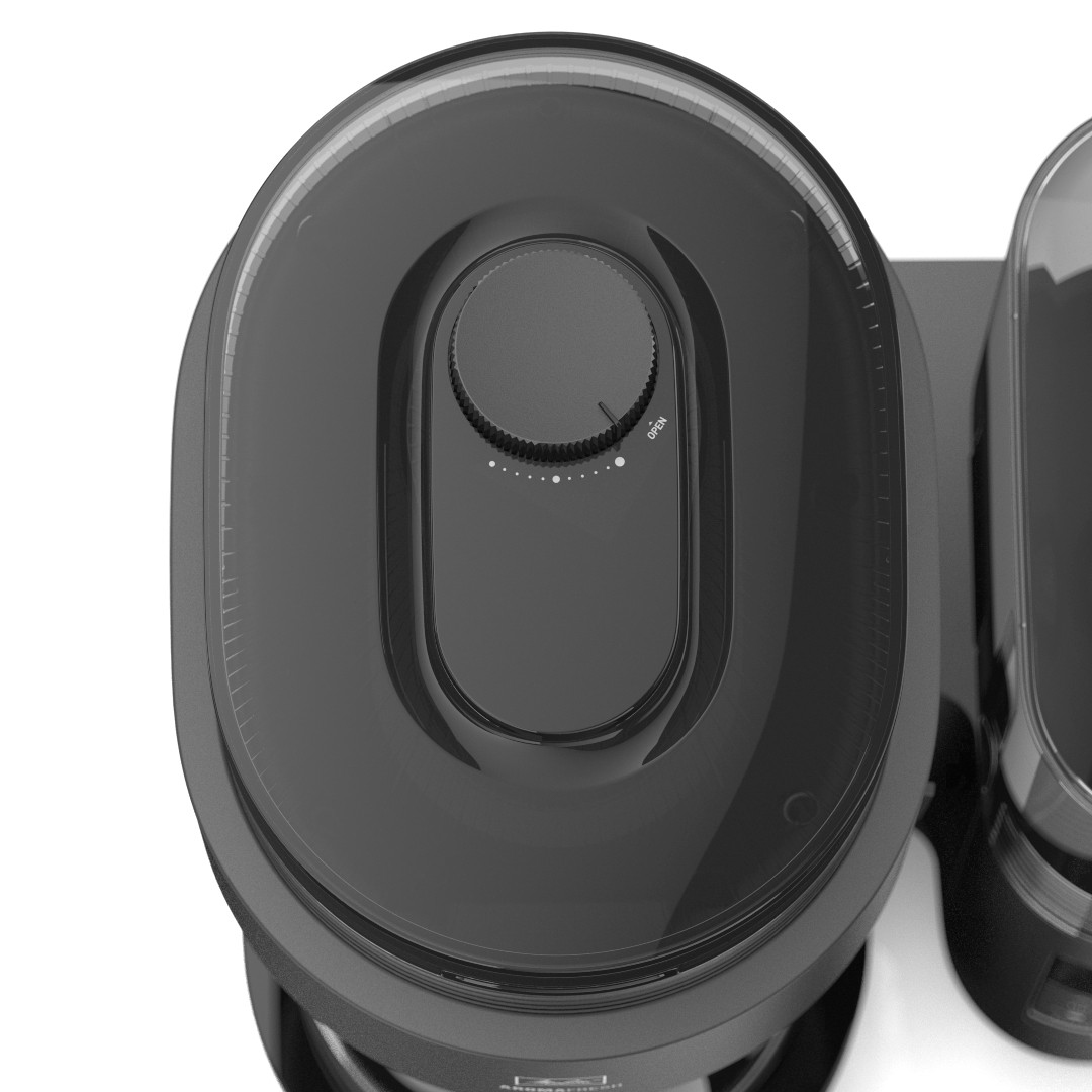 Widok z góry na ciemnoszare urządzenie z owalną pokrywą i pokrętłem z napisem 'otwarte'.