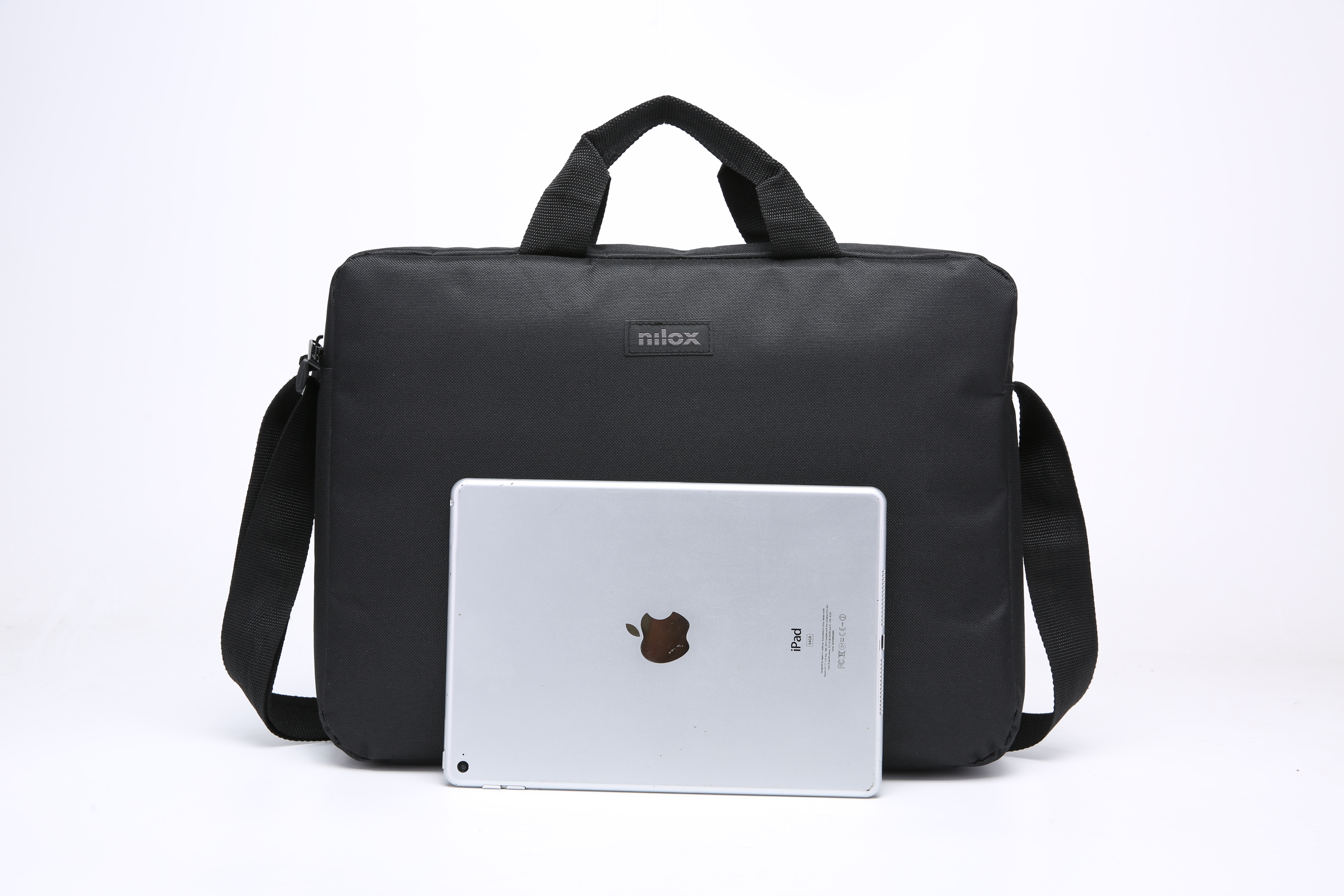 Una bolsa negra Nilox con asa y bandolera. Un iPad está frente a la bolsa, sobre un fondo blanco.