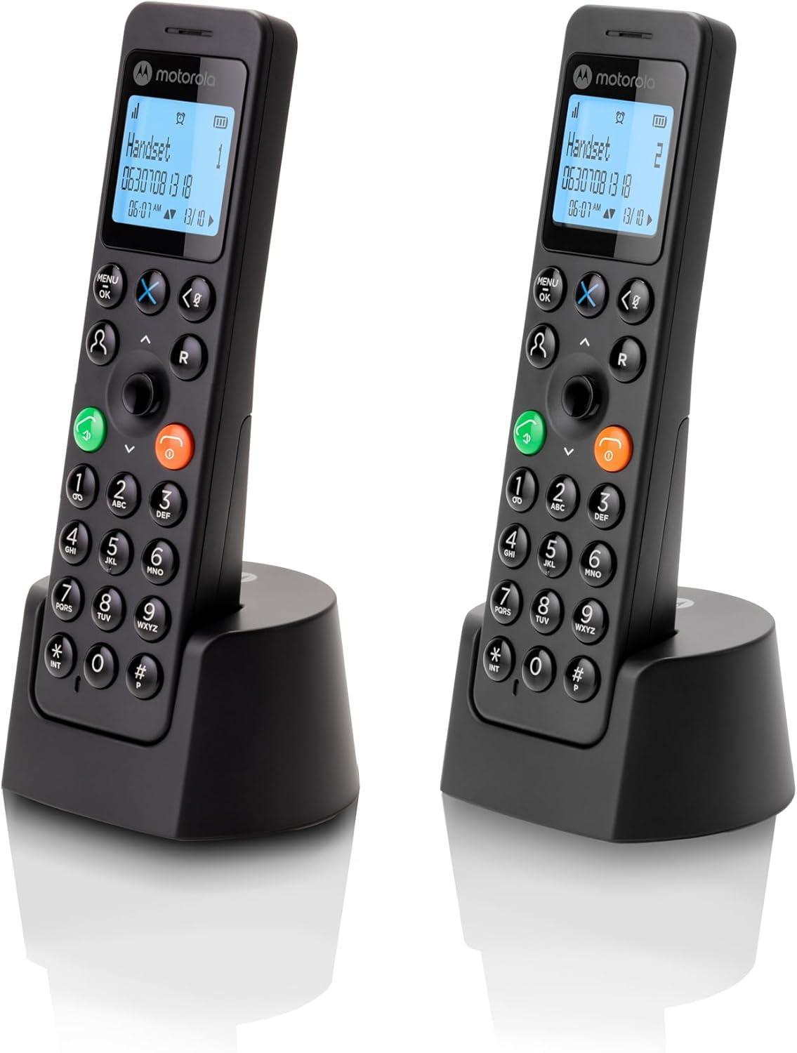 Dos teléfonos inalámbricos Motorola negros en bases de carga. Cada uno muestra una pantalla y tiene teclados numéricos.