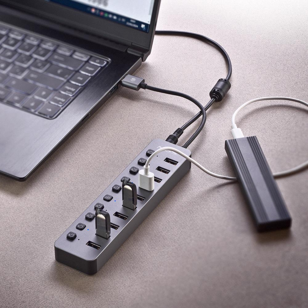 Ein Laptop ist mit einem USB-Hub verbunden, an dem mehrere Geräte angeschlossen sind. Eine Powerbank ist ebenfalls angeschlossen.