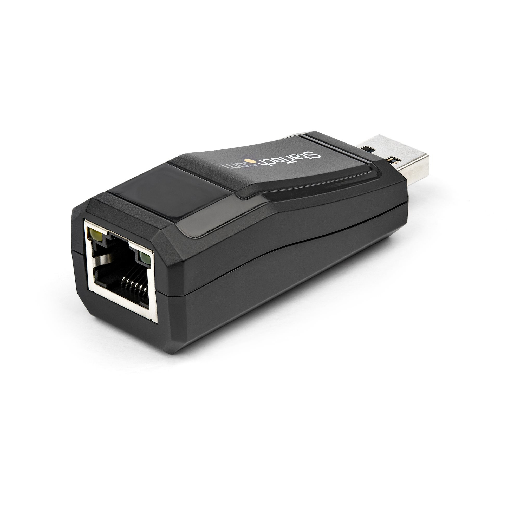 Adaptador Ethernet USB negro Startech. Tiene un puerto RJ45 y un conector USB. Fondo blanco.