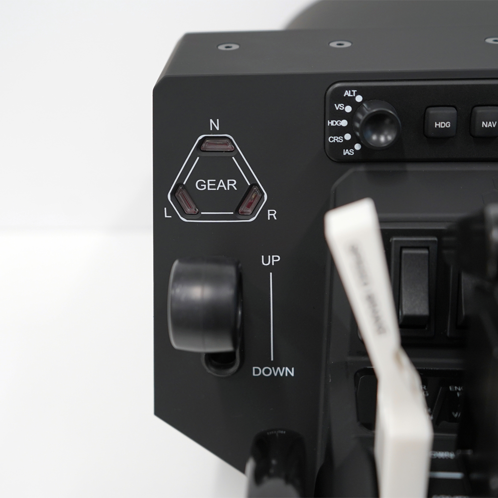 A close-up of a black aircraft control panel. It features switches, dials, and indicators for gear, altitude, heading, and navigation.