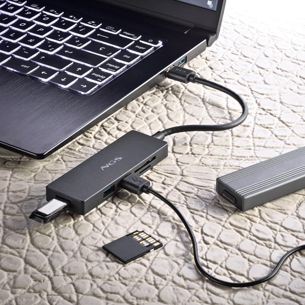 Ein Laptop mit angeschlossenem USB-Hub. Ein USB-Stick und eine Speicherkarte sind eingesteckt. Eine externe Festplatte liegt daneben.