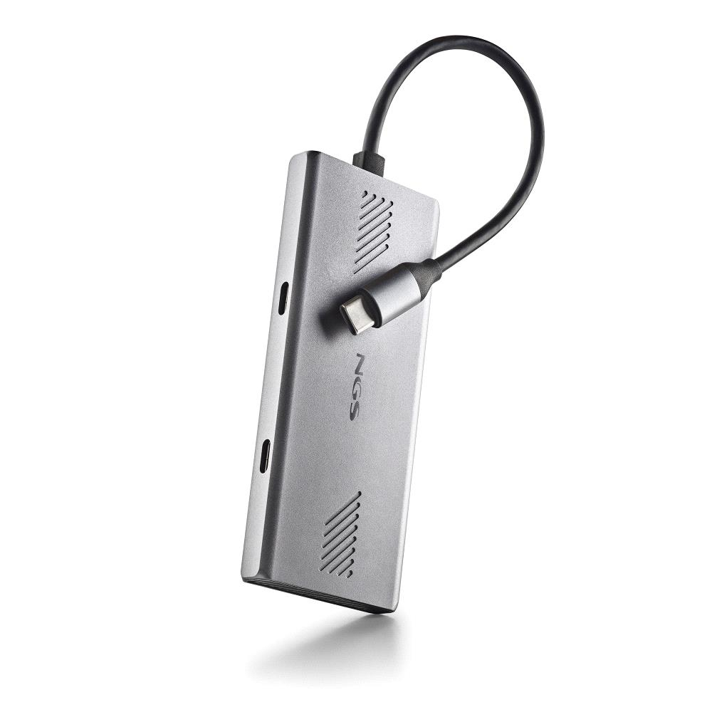 Ein silberner NGS USB-C-Hub mit einem schwarzen Kabel. Der Hub hat das NGS-Logo und mehrere Anschlüsse. Der Hintergrund ist weiß.