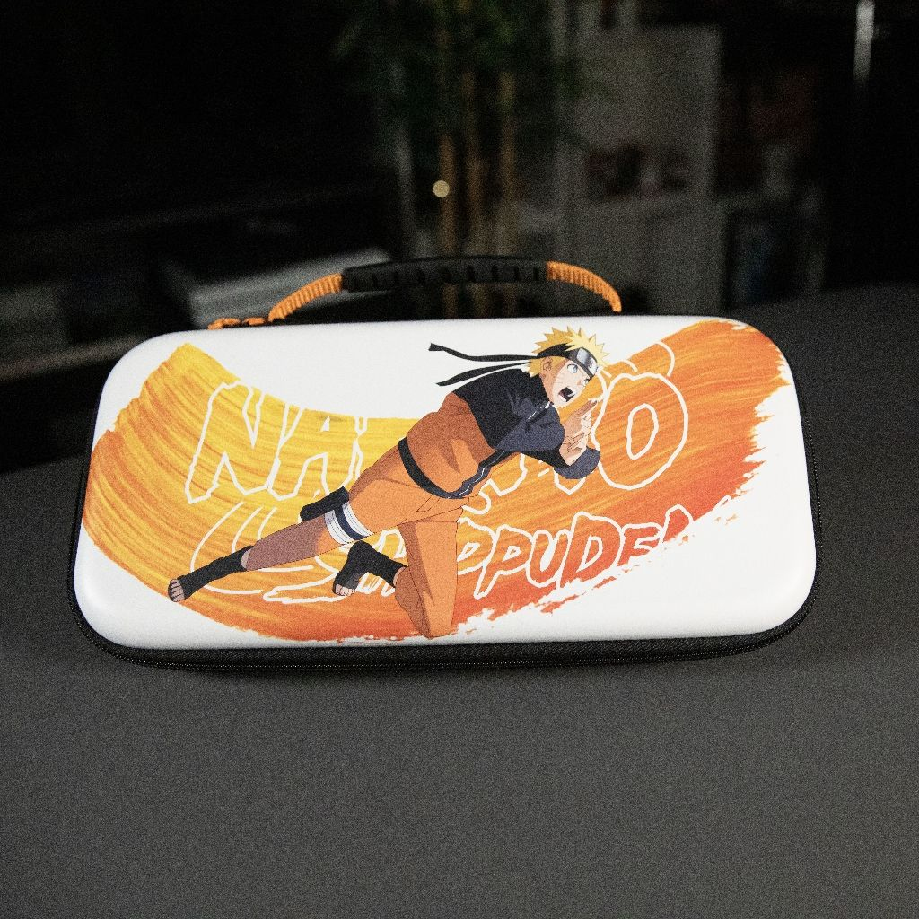 A white case with a Naruto design. Naruto is depicted in motion, against an orange and yellow background. Black handle on top.